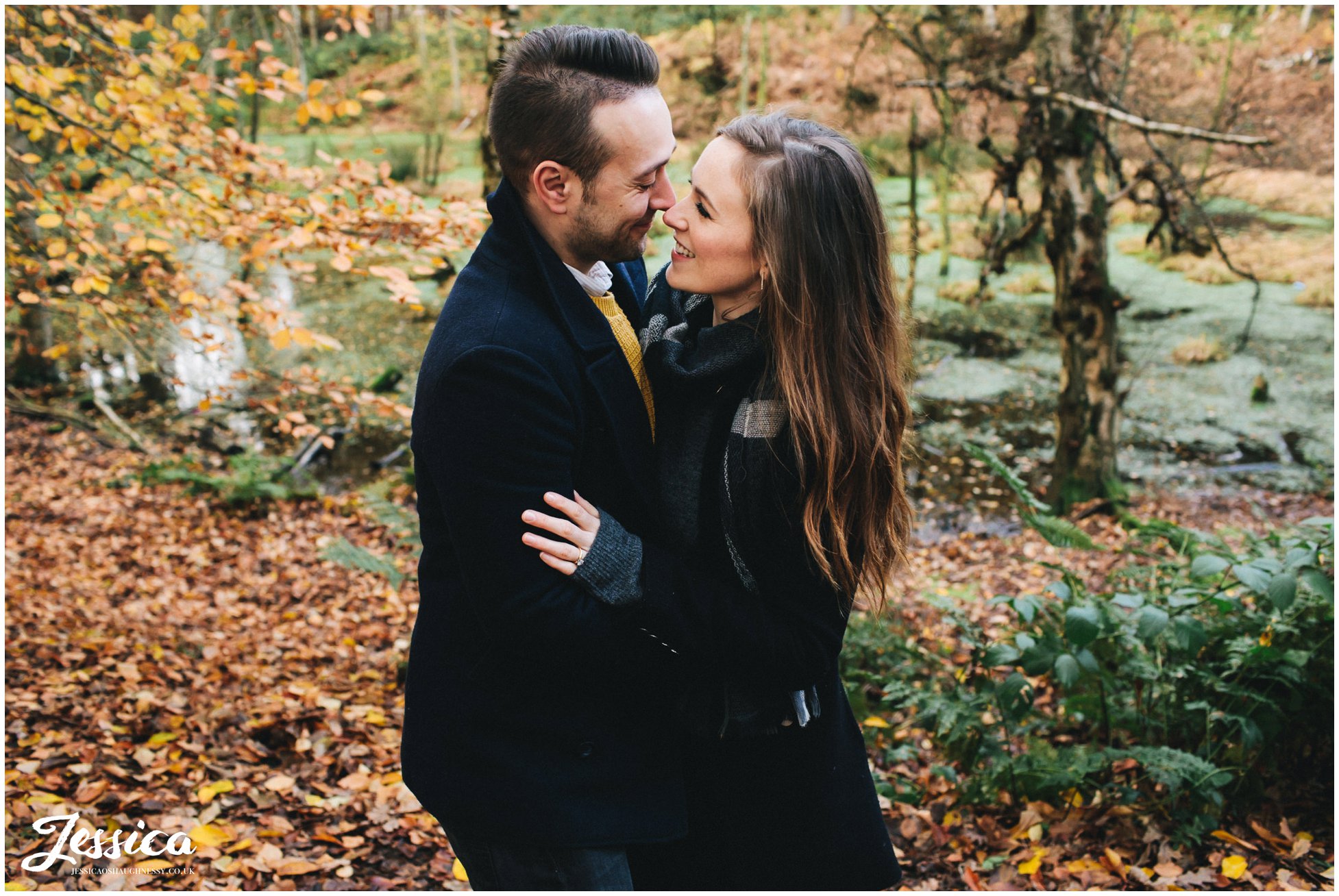 couple embracing in front of the lake at delamere forest in cheshire