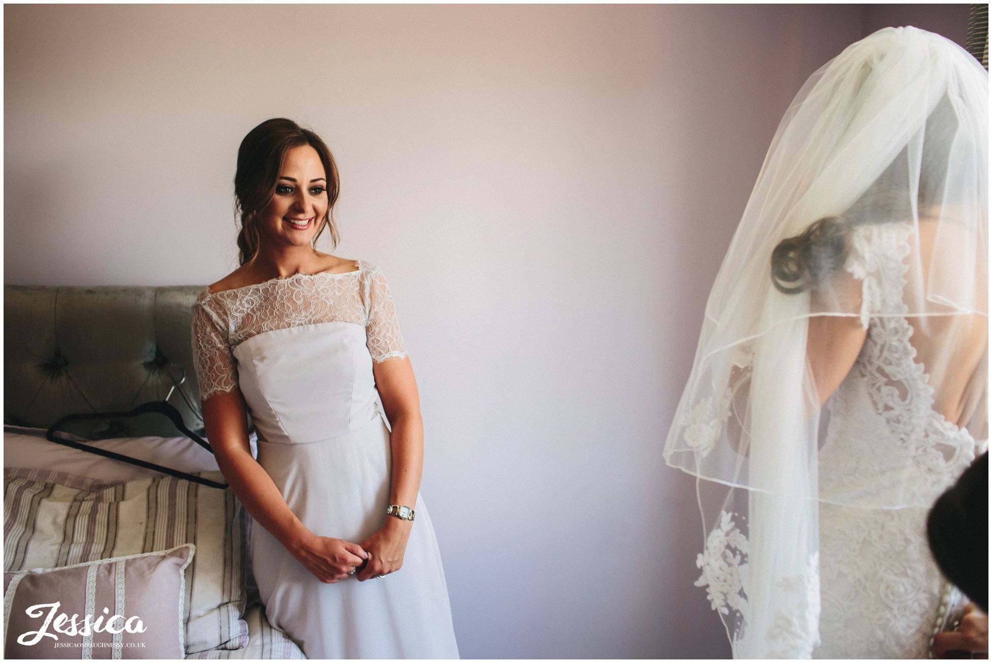 bridesmaid admires the bride in her dress