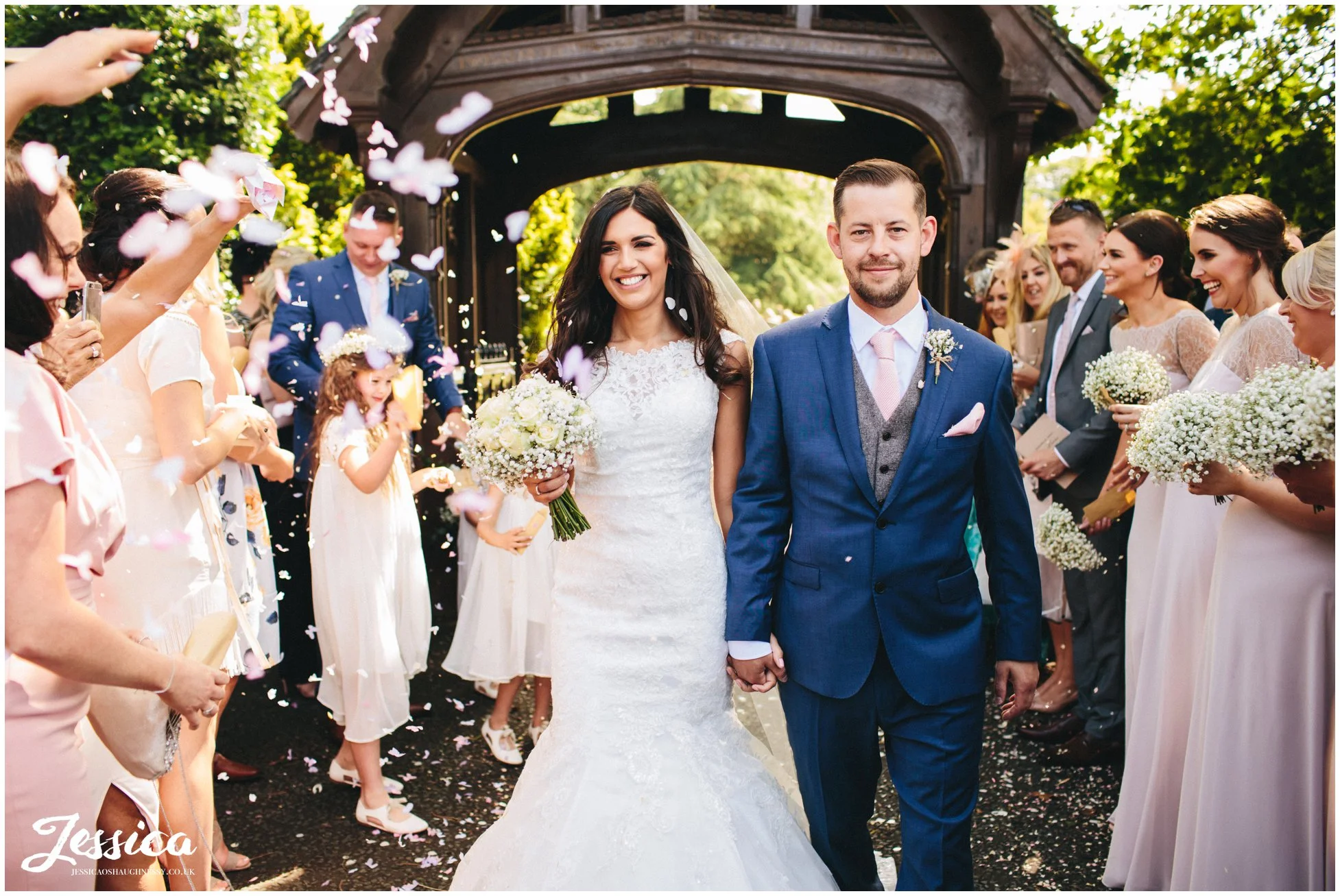 newly wed's exit the wirral church through a confetti line