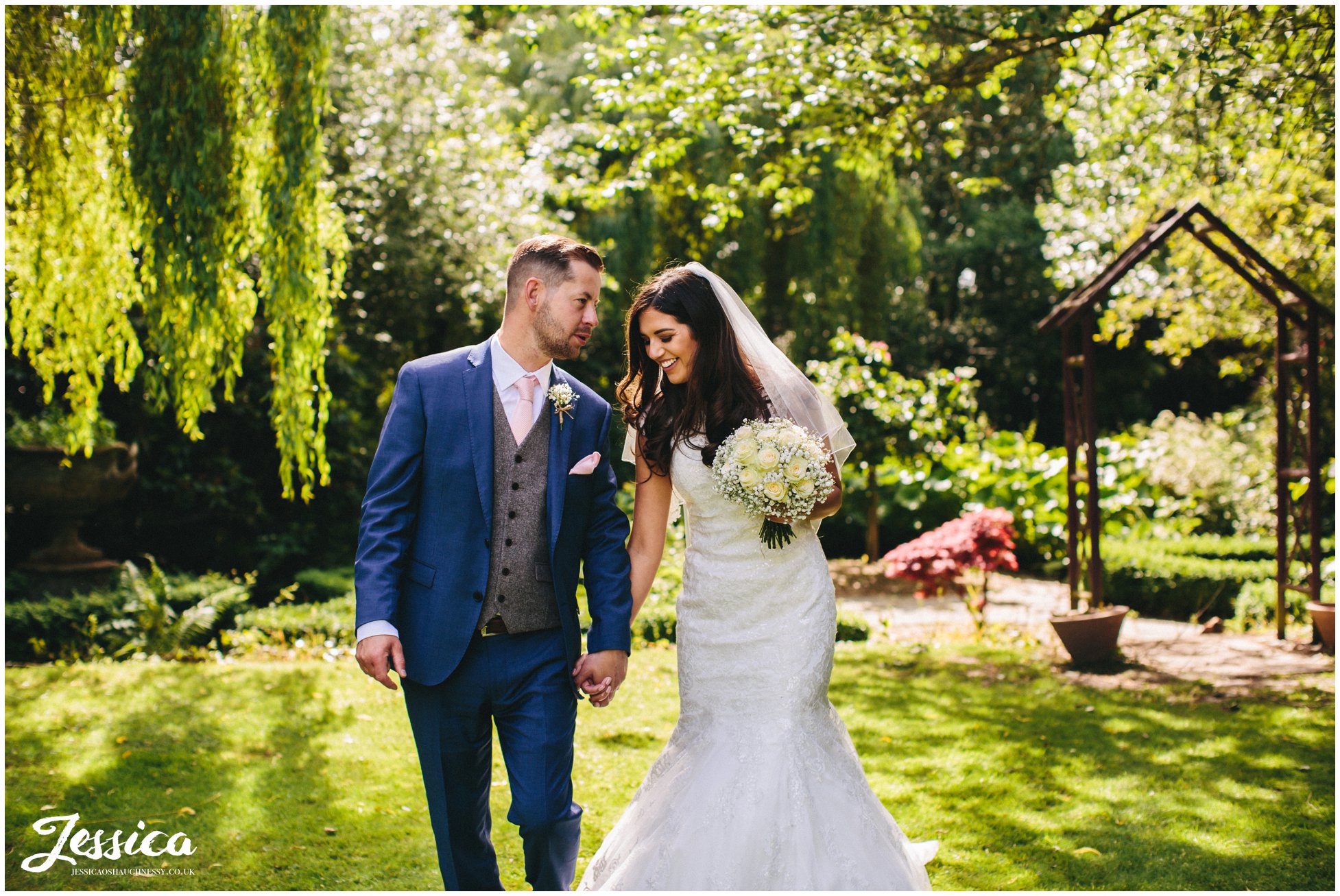 newly married couple walk through brook hall hotel's grounds