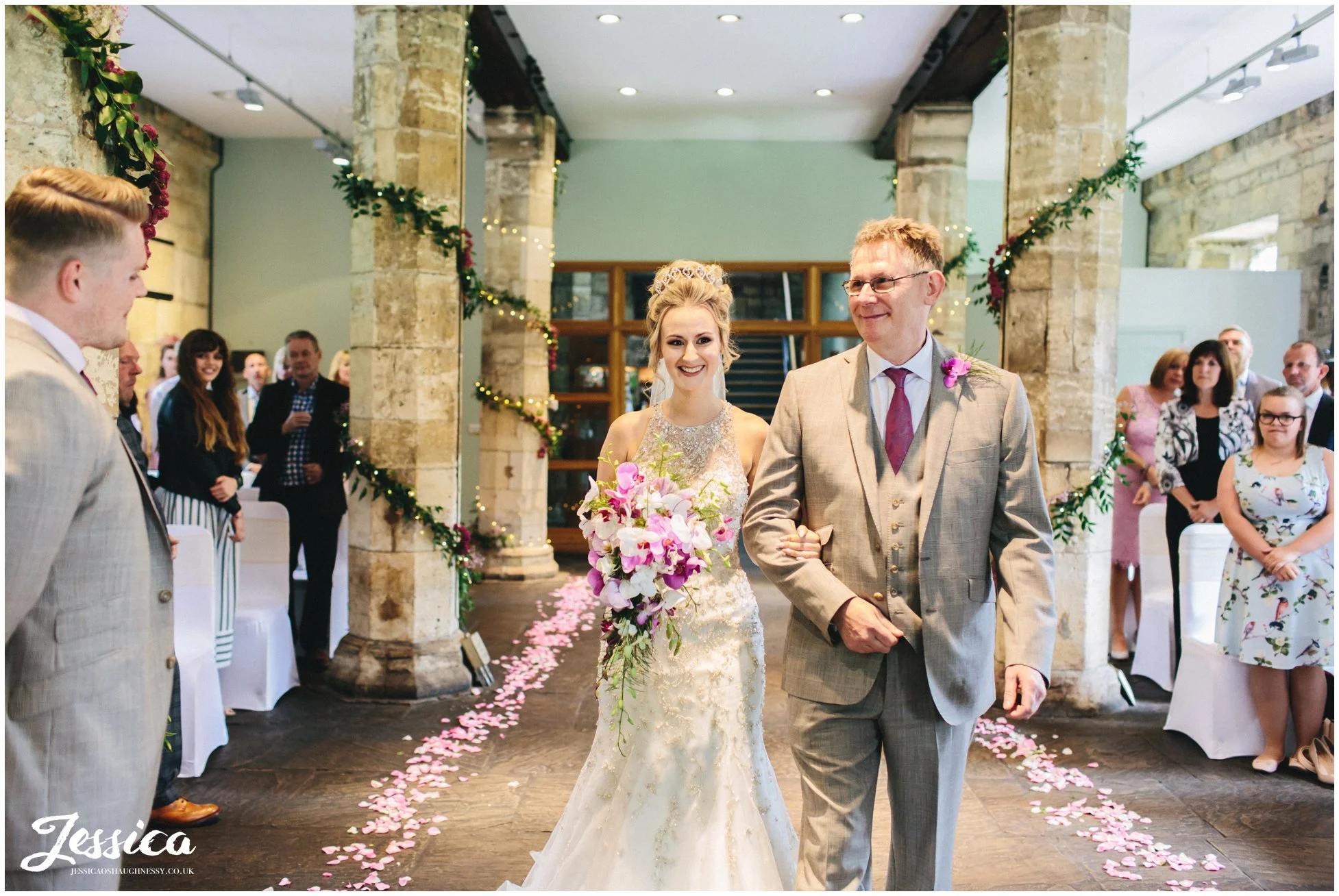 bride walks down the aisle with her father