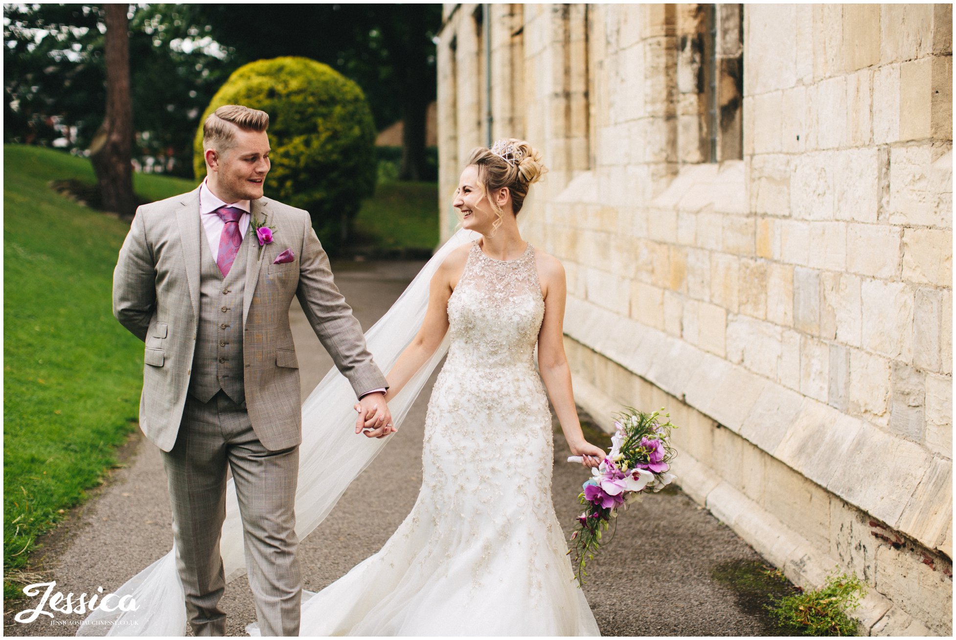 husband & wife walk holding hands on their wedding day