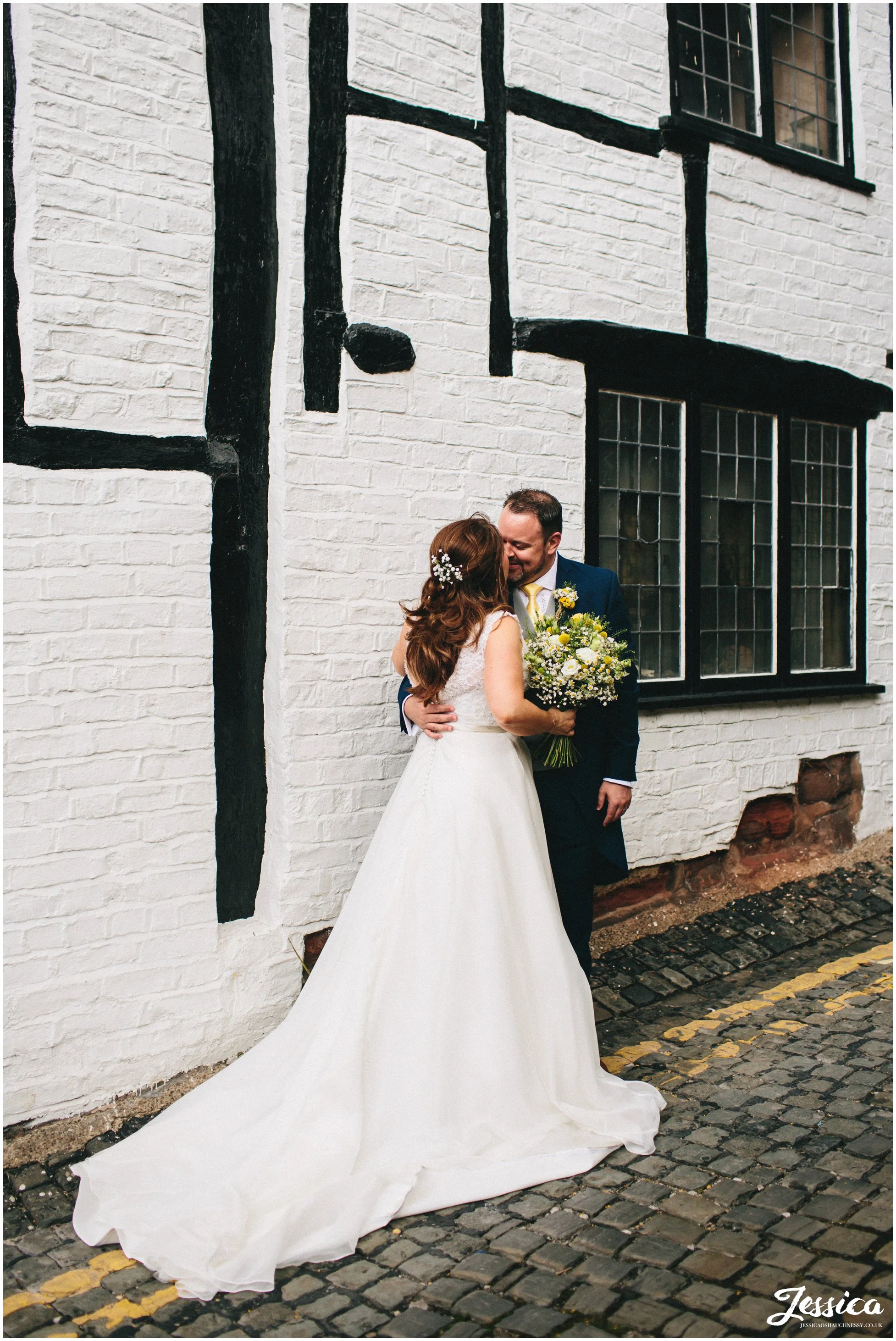 bride & groom kiss outside chester's tudor buildings