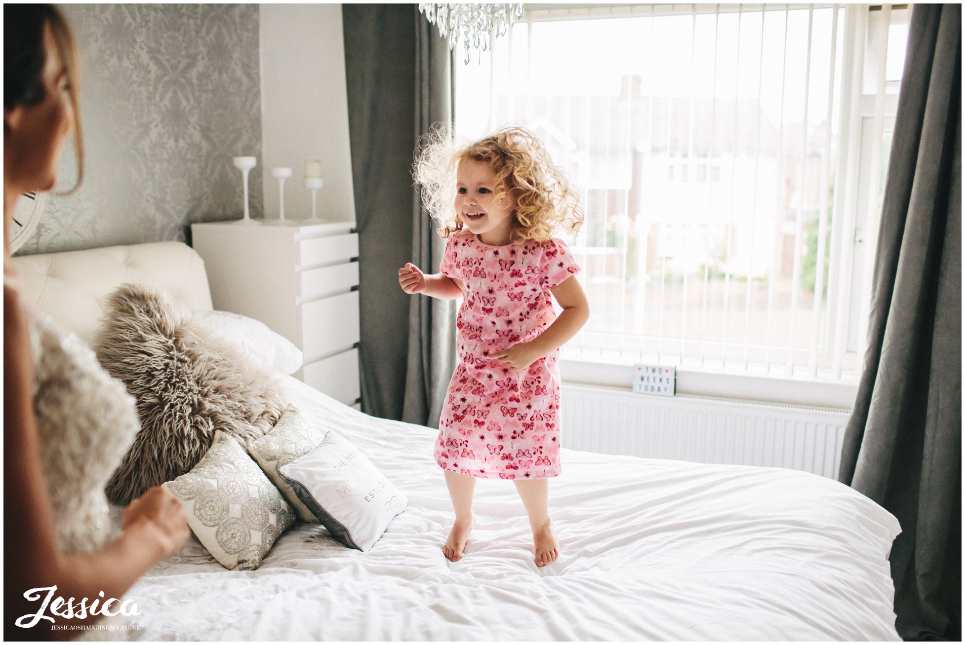 flower girl jumps on bed