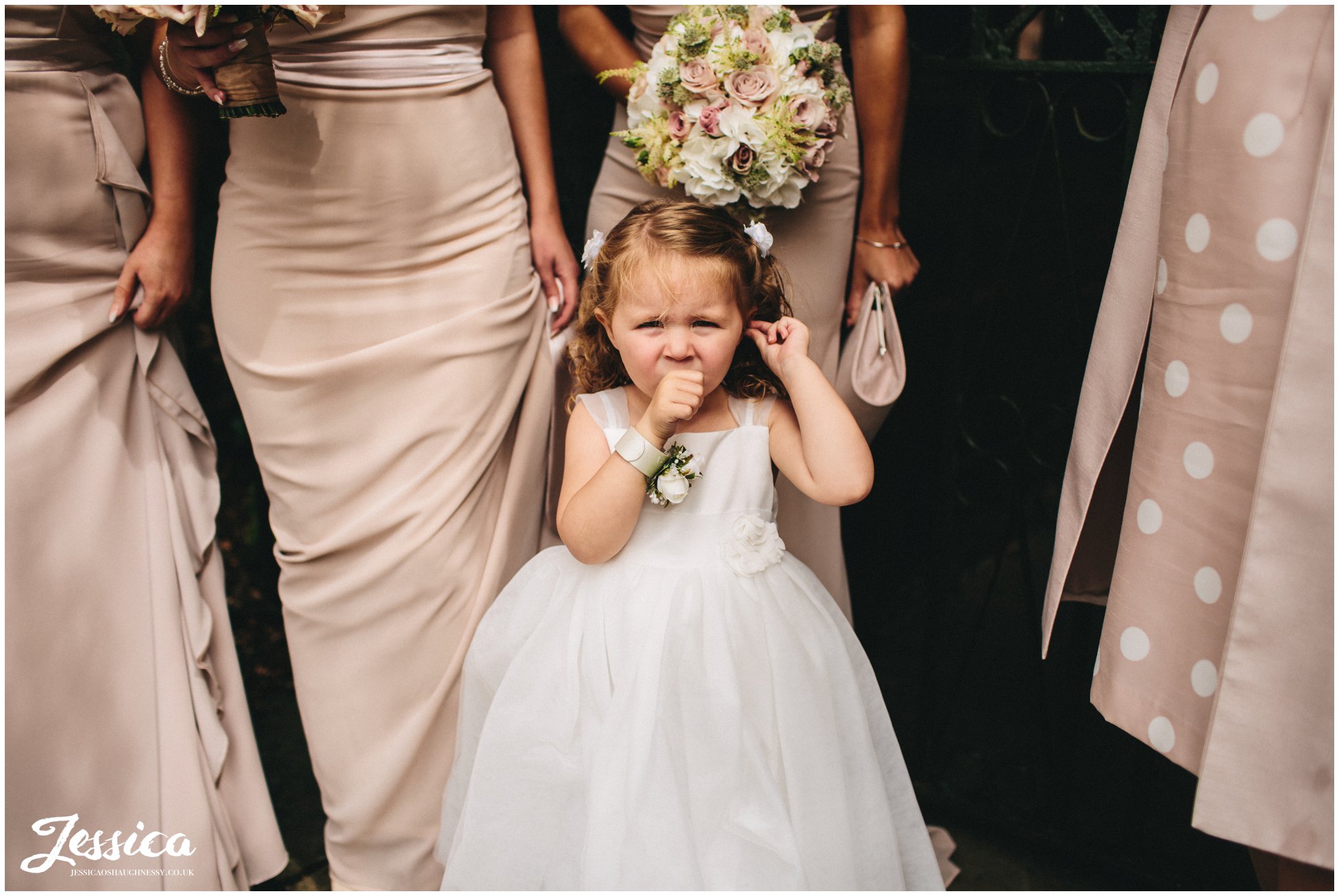 flower girl waits for the bride to arrive outside the church