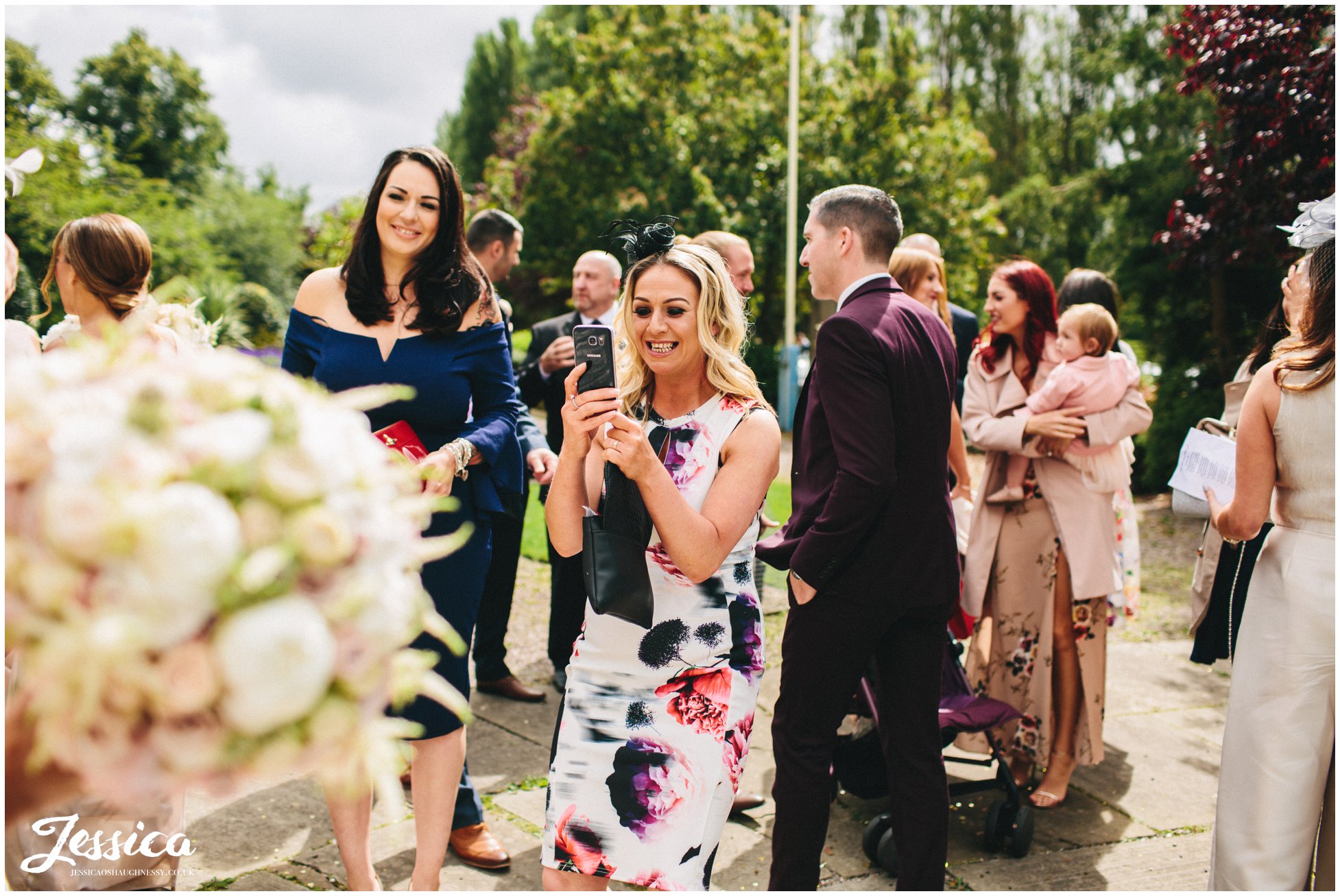 guests take photos of the bride after the wedding ceremony