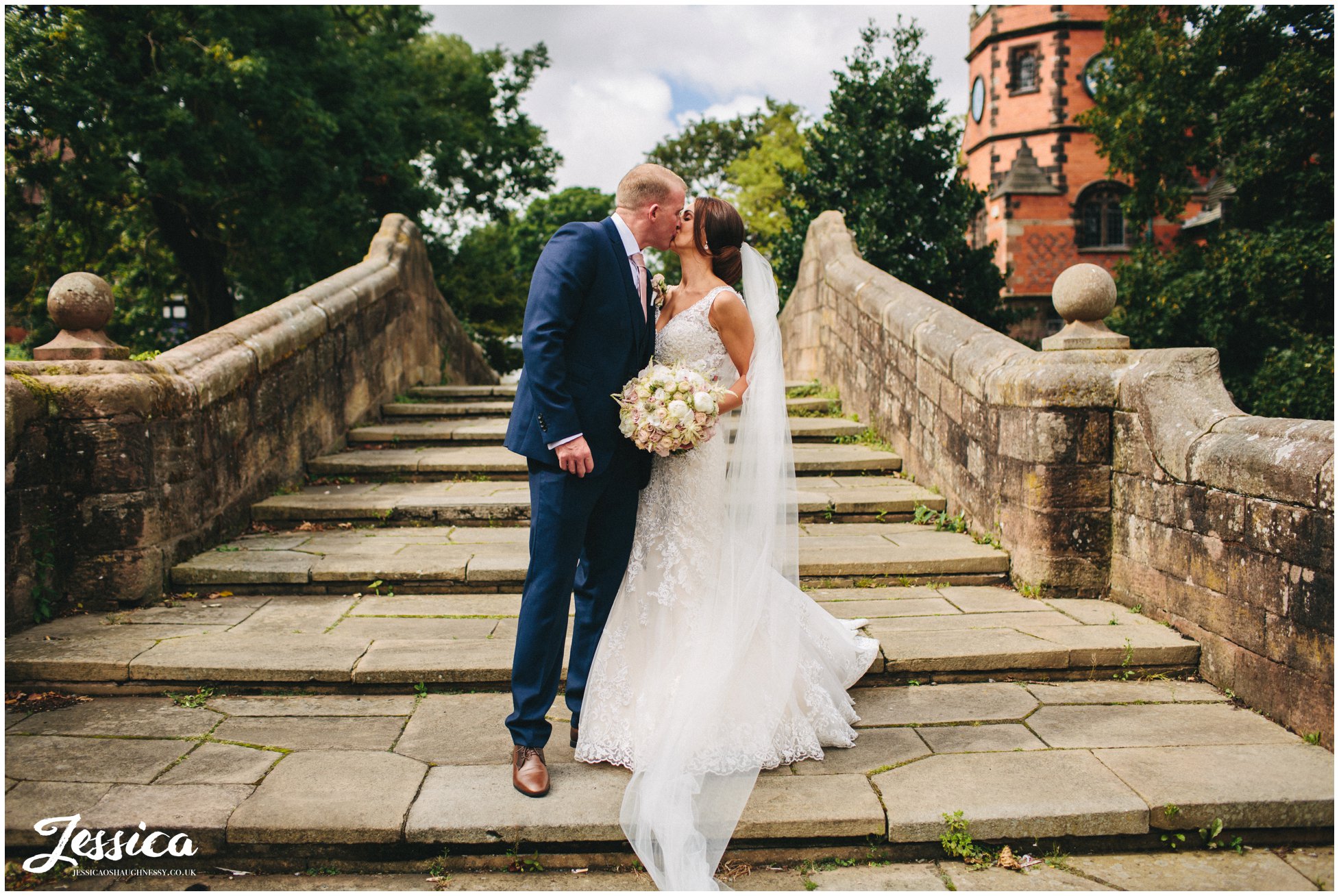 husband and wife kiss on the bridge in port sunlight