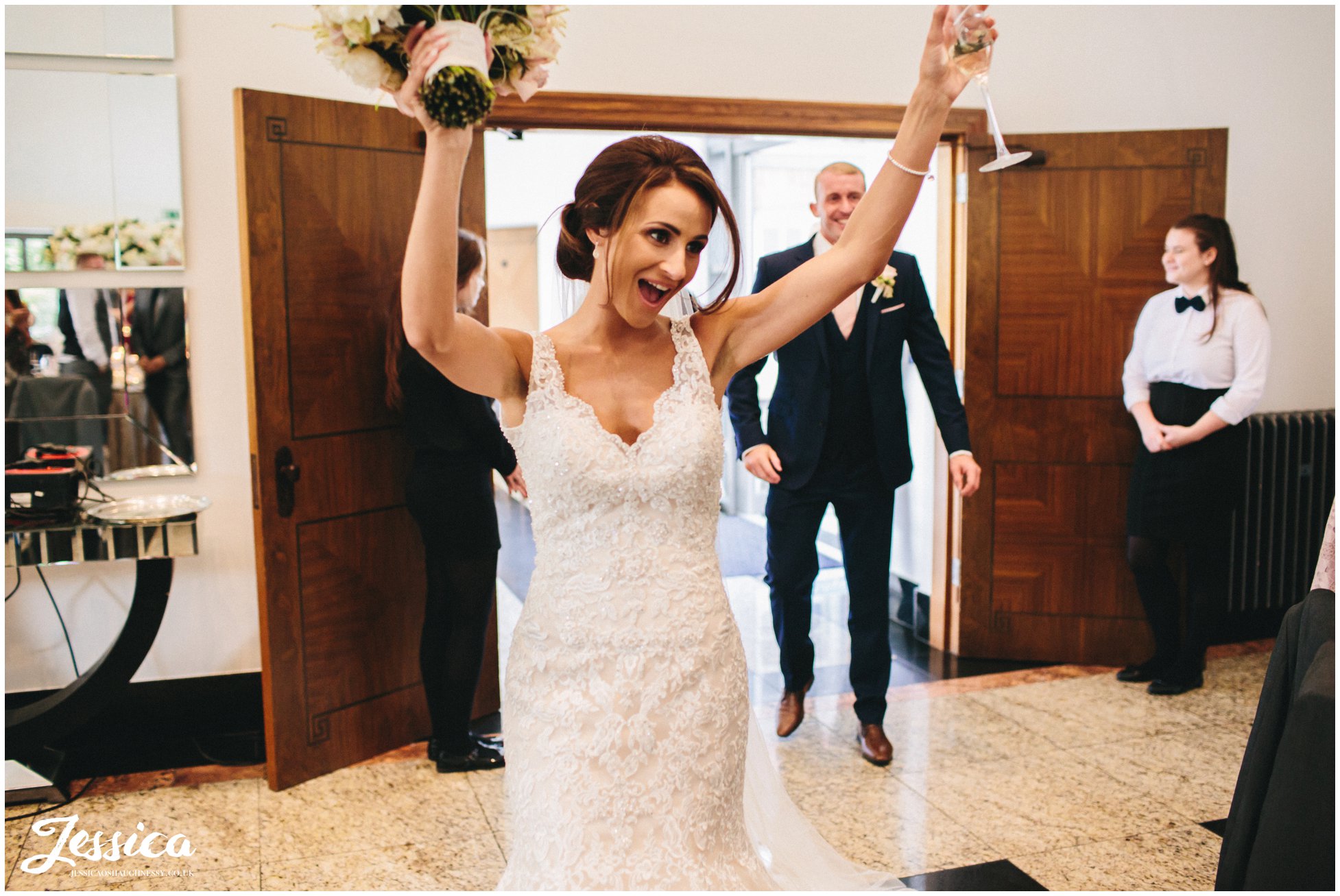 bride dances as she enters the room for the wedding breakfast