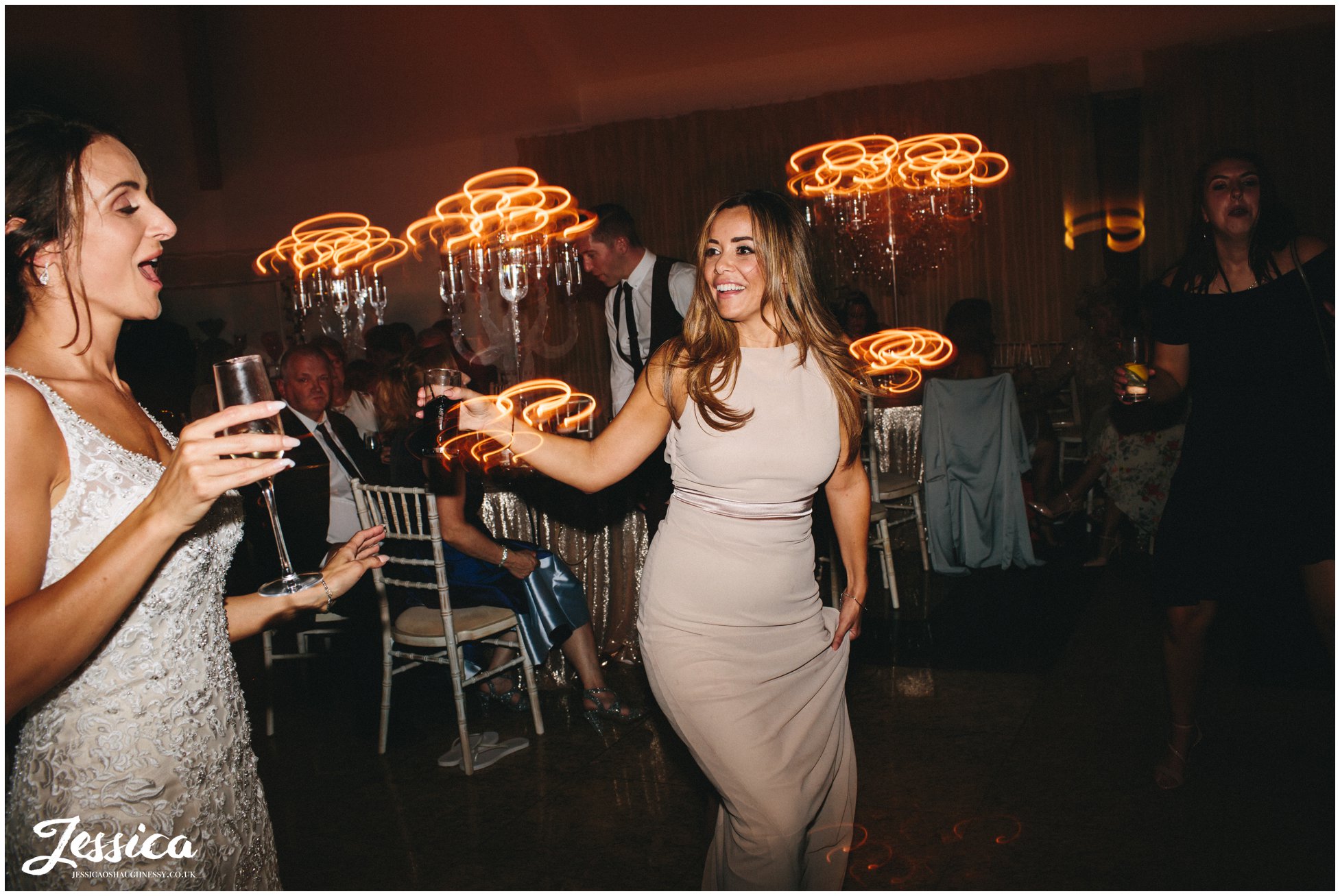 bride dances with her bridesmaid at her wirral wedding