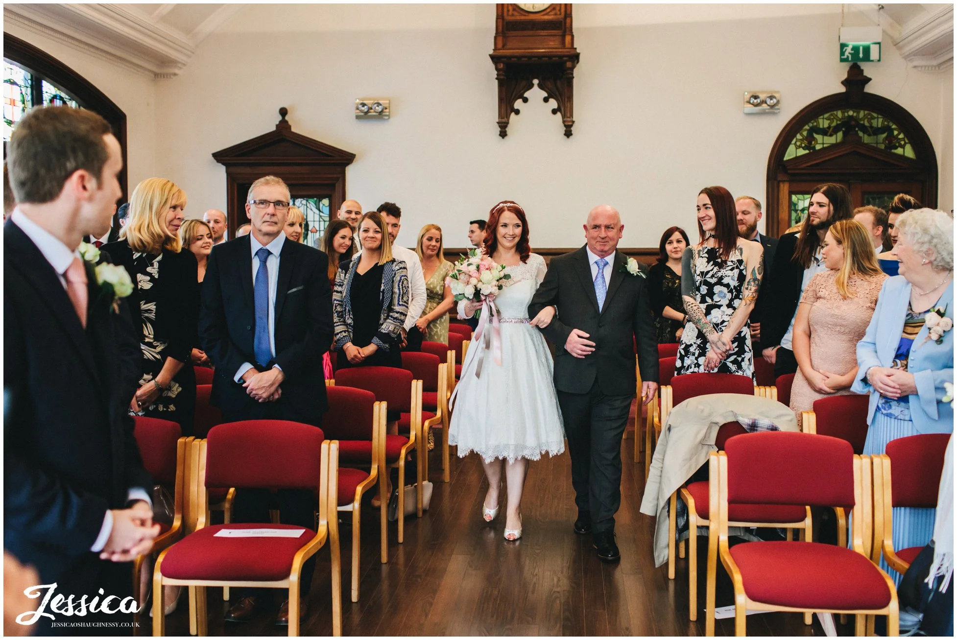 bride walks down the aisle with her father