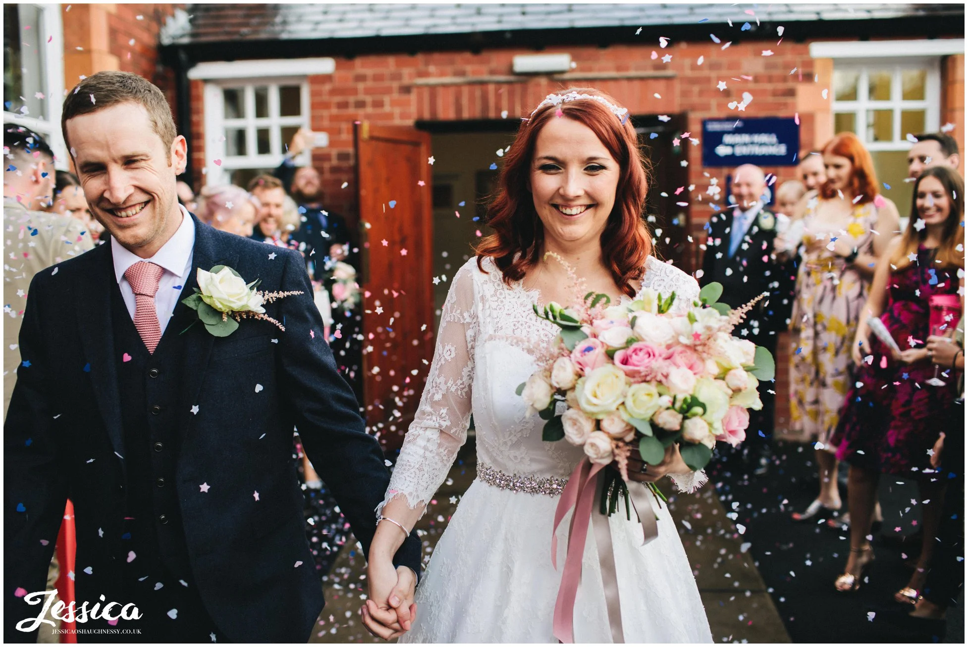 husband and wife walk through their confetti line