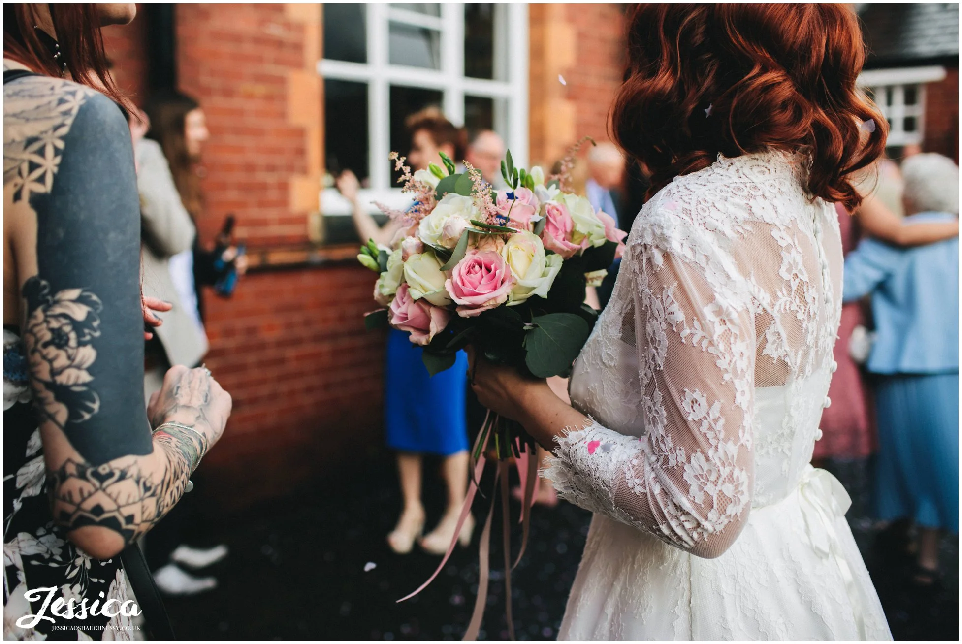 bride chats to friends holding her bouquet