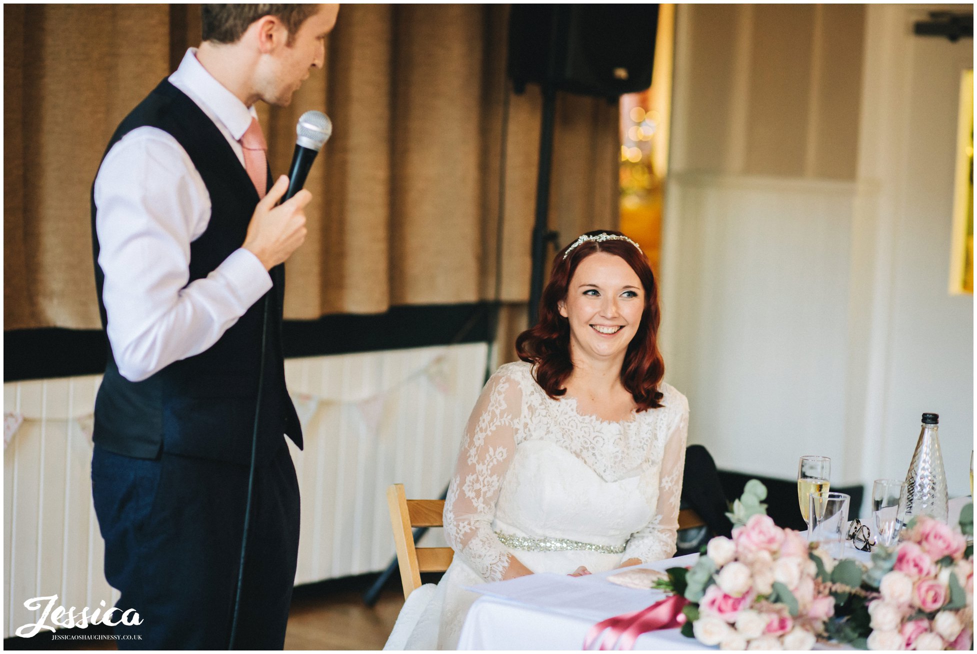 bride laughs as groom gives his speech