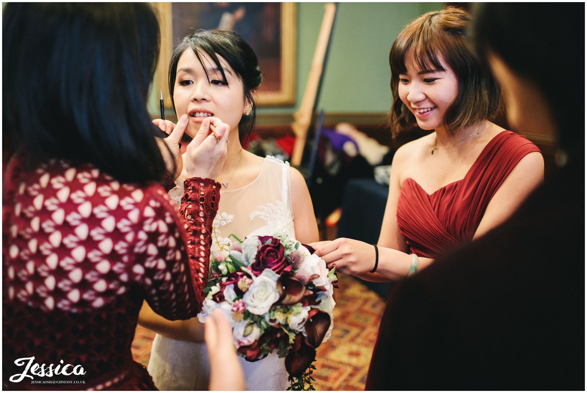 bride touches up lipstick before the ceremony