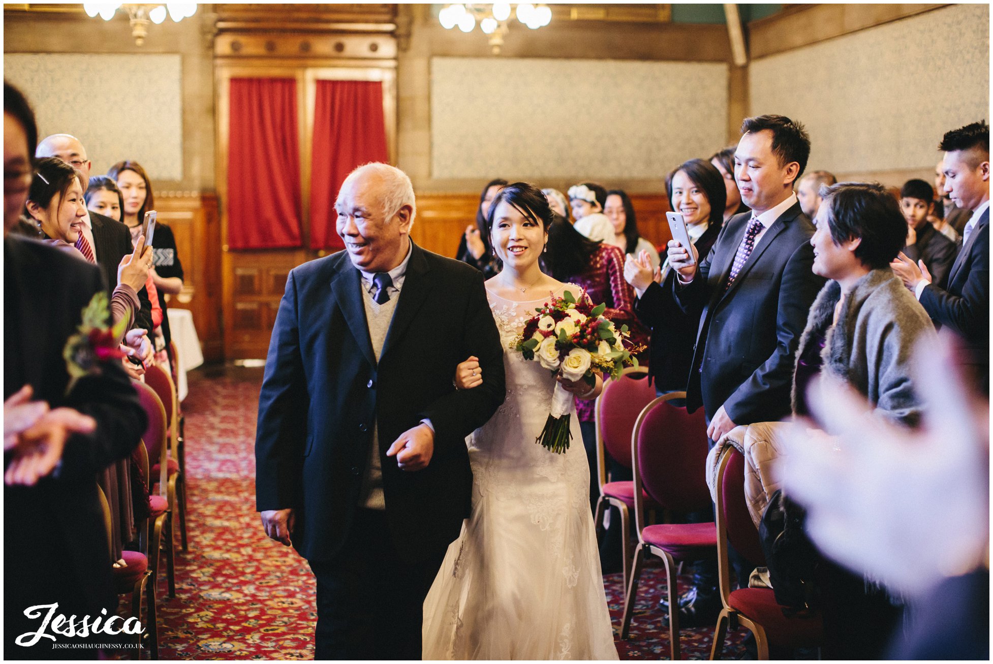 bride walks down the aisle with her father