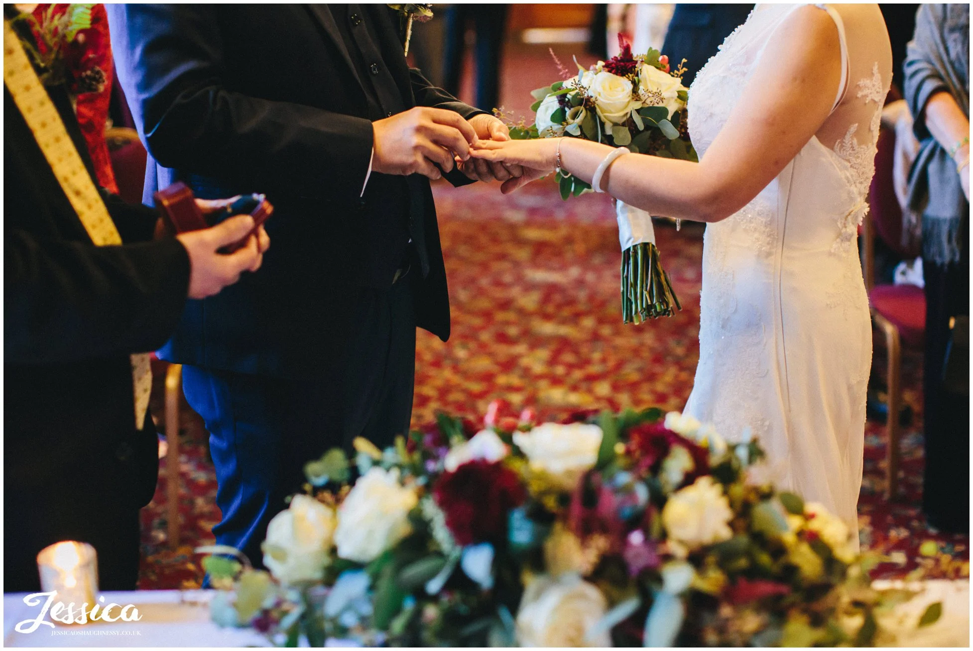 groom puts ring on the brides finger