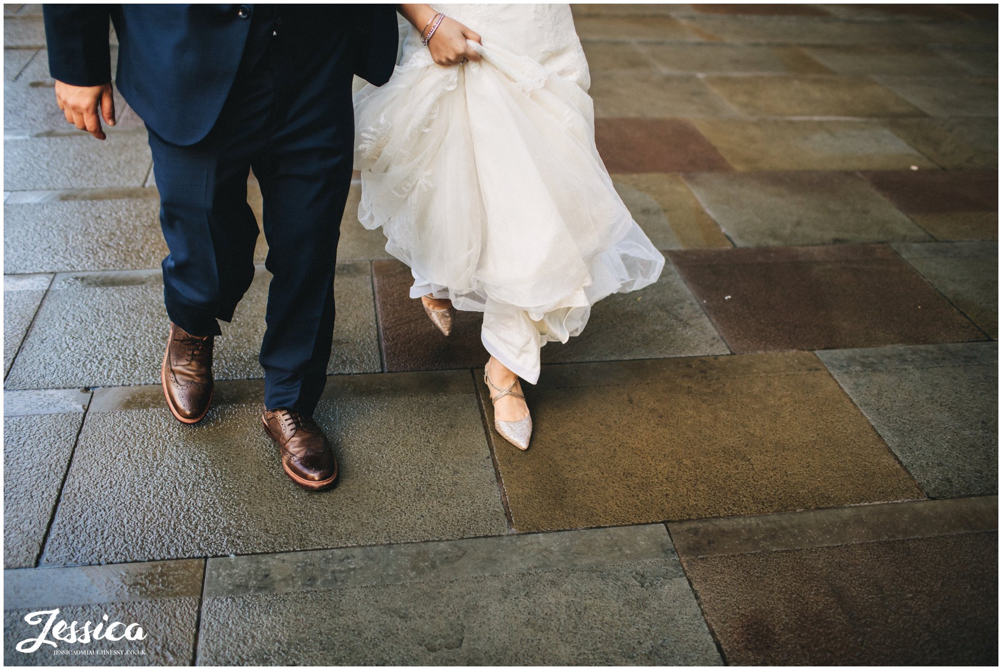 detail shot of newly wed's feet walking through a rainy manchester