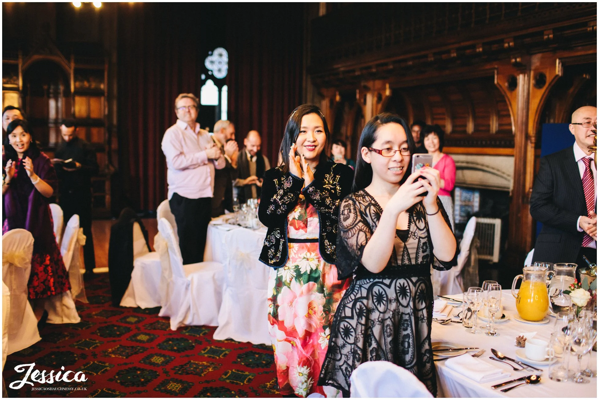 guests take photos of the couple making their entrance