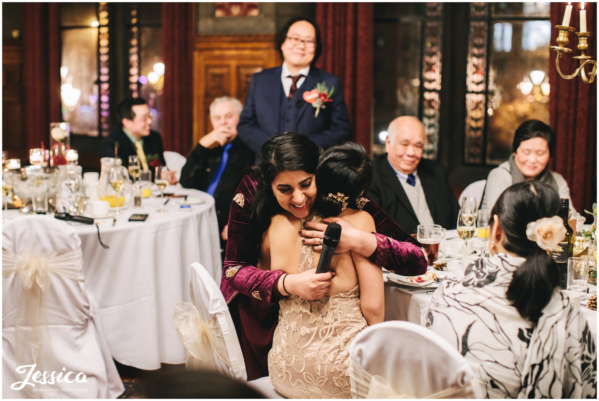 bridesmaid hugs the bride after she finishes her speech