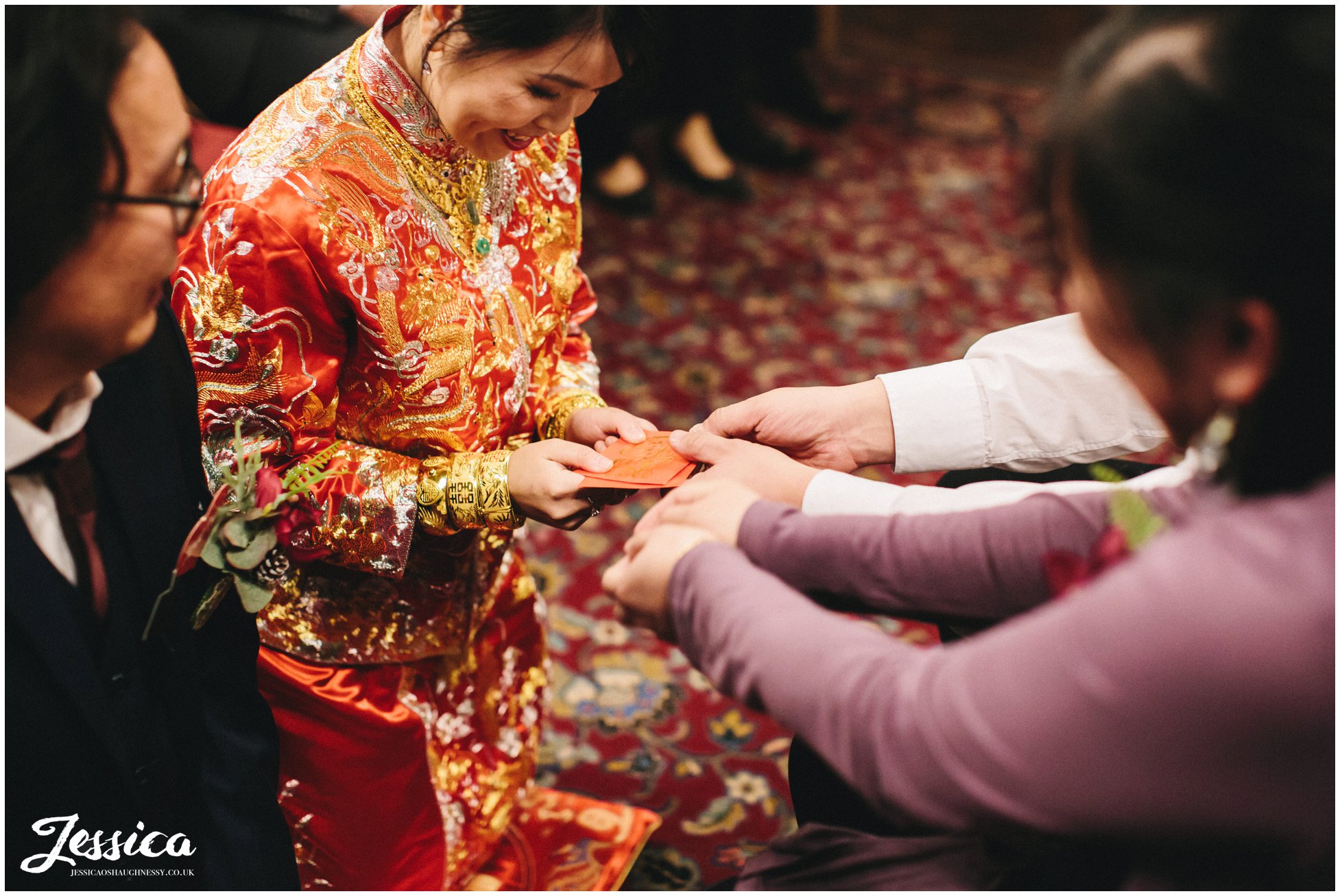 couple receive money from guests during the chinese tea ceremony