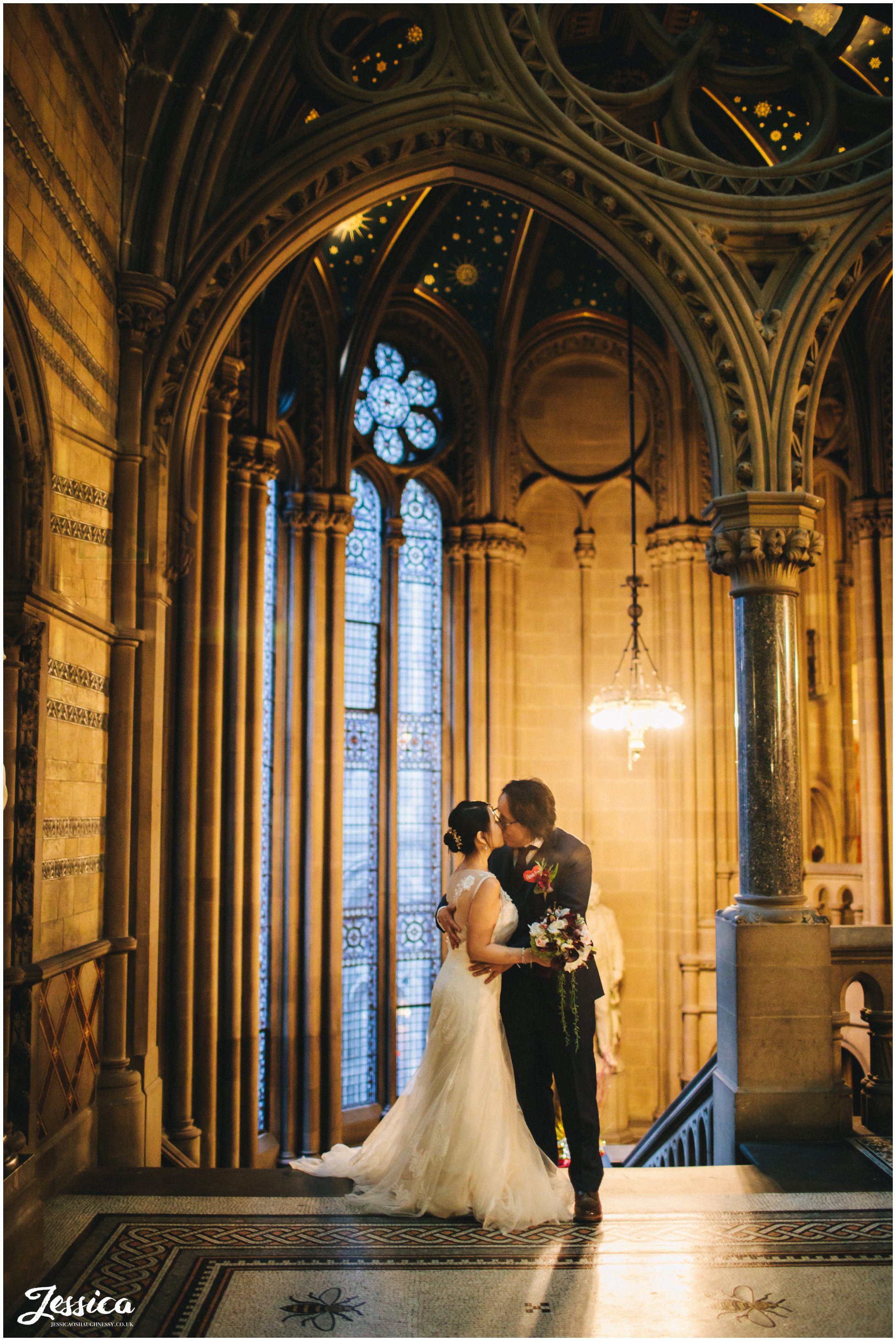 newly wed's kiss on the stairs of manchester town hall in the evening