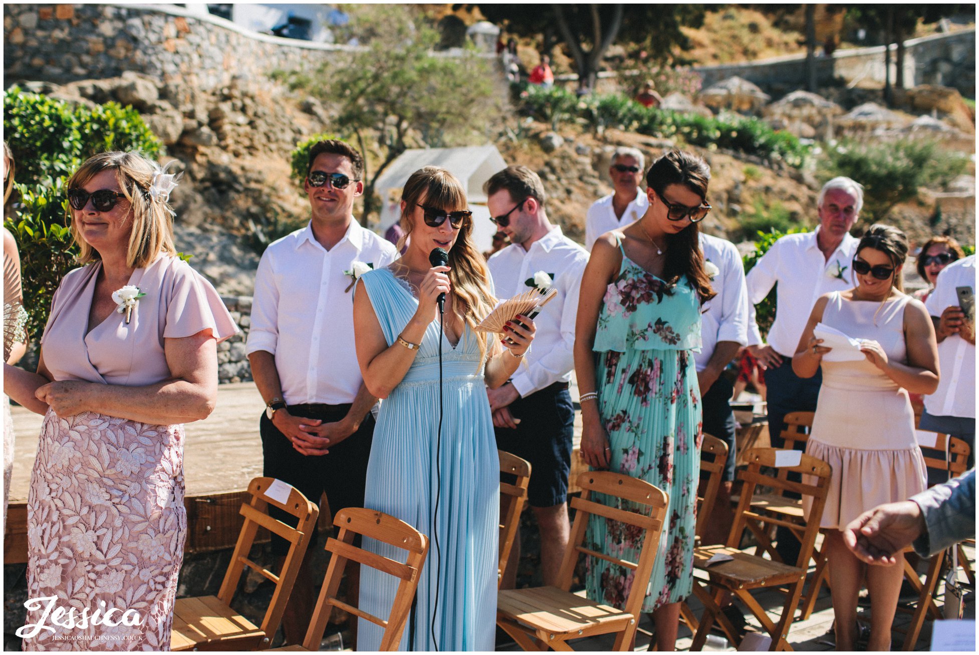 wedding guests give a reading during the ceremony in greece