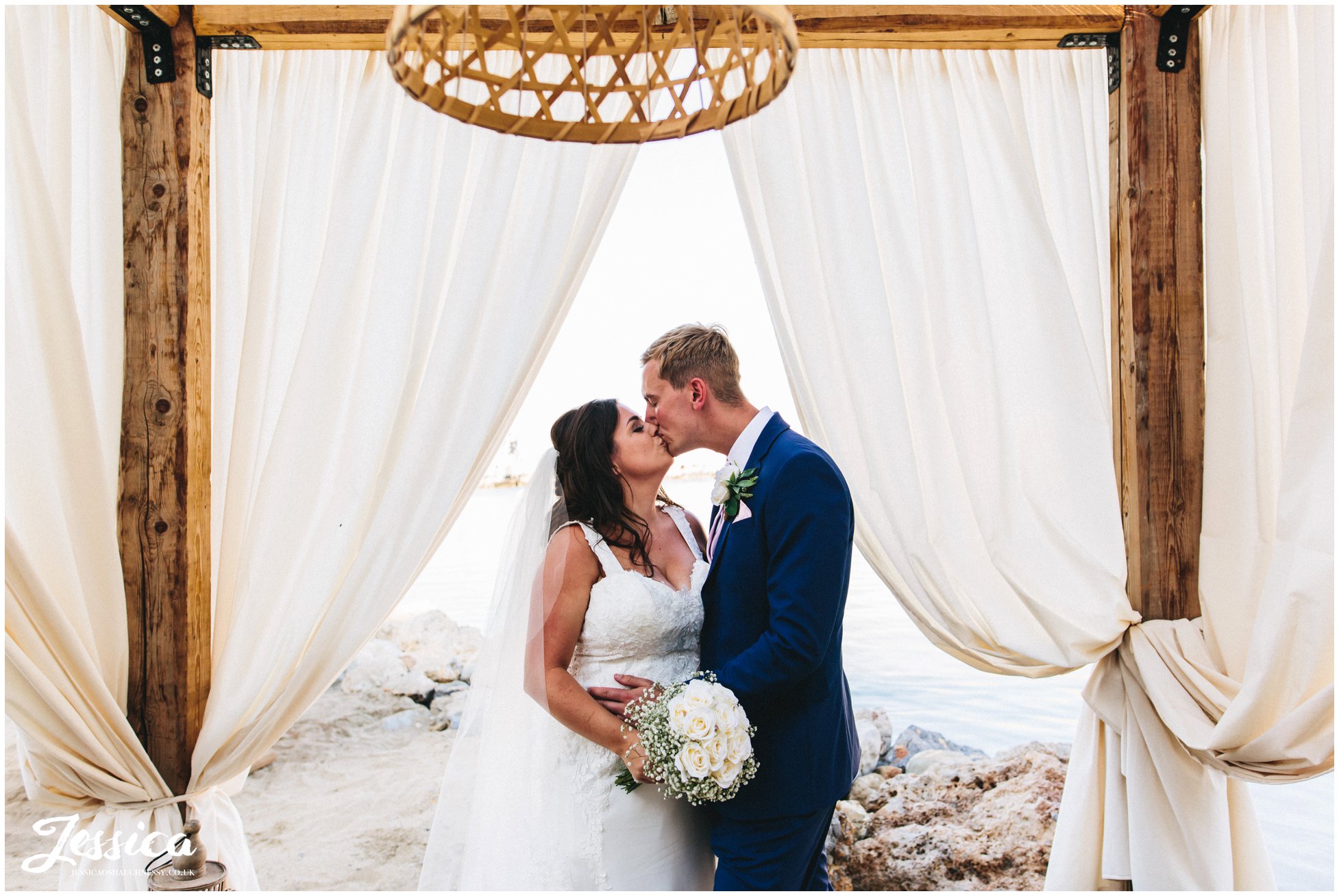 newly wed's kiss under the drapes at Tambakio Restaurant on st paul's bay