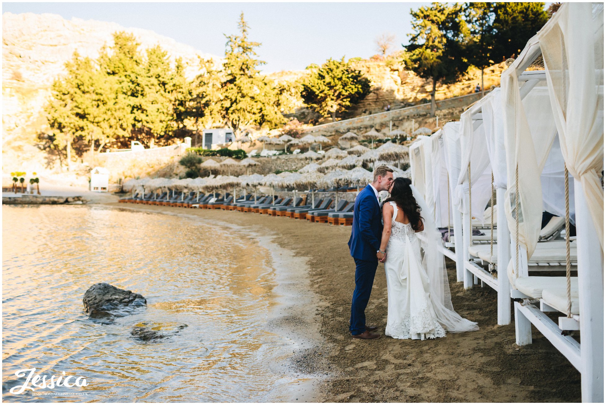 husband and wife kiss on the beach in rhodes