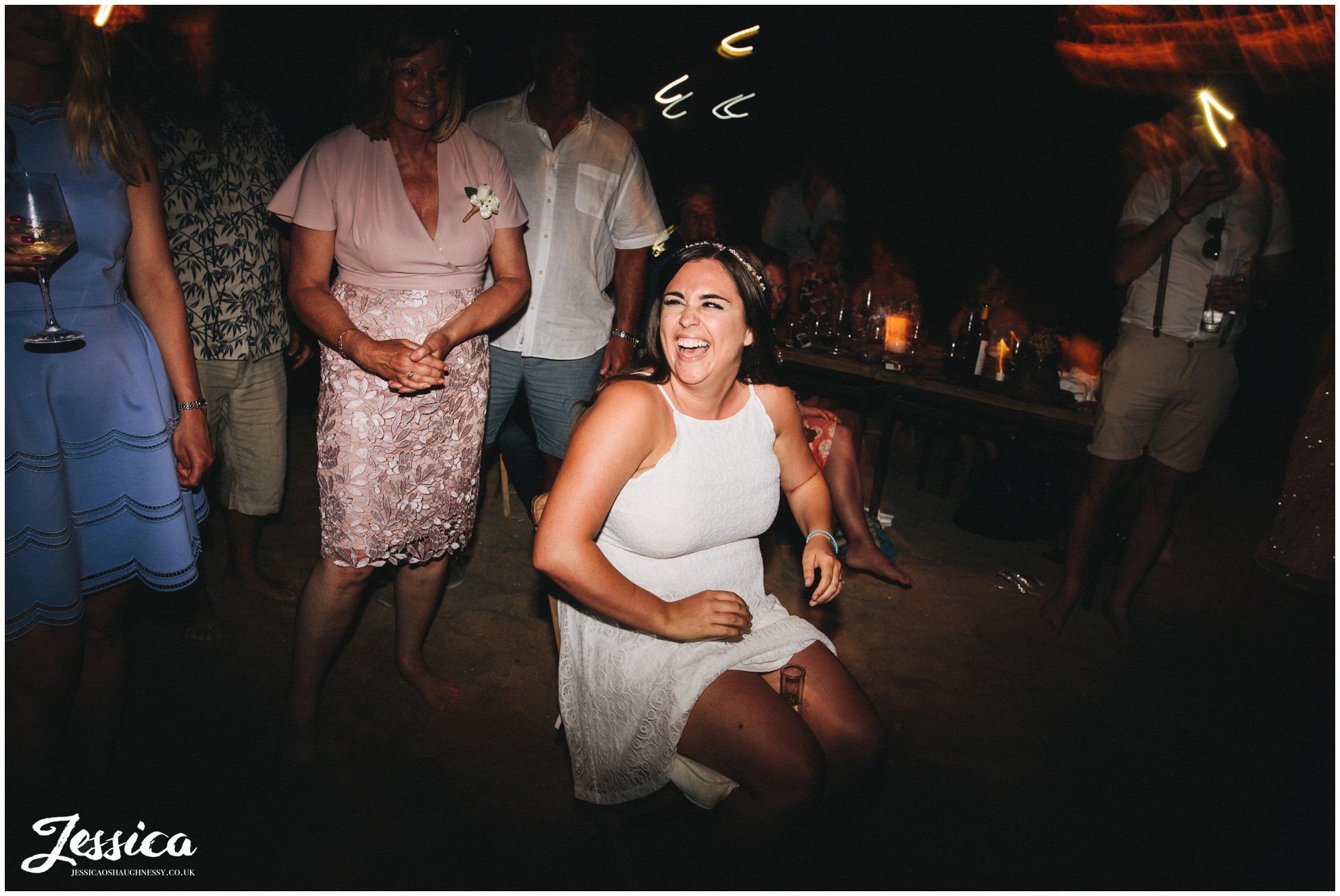 bride sits with a shot on her legs for the groom to find