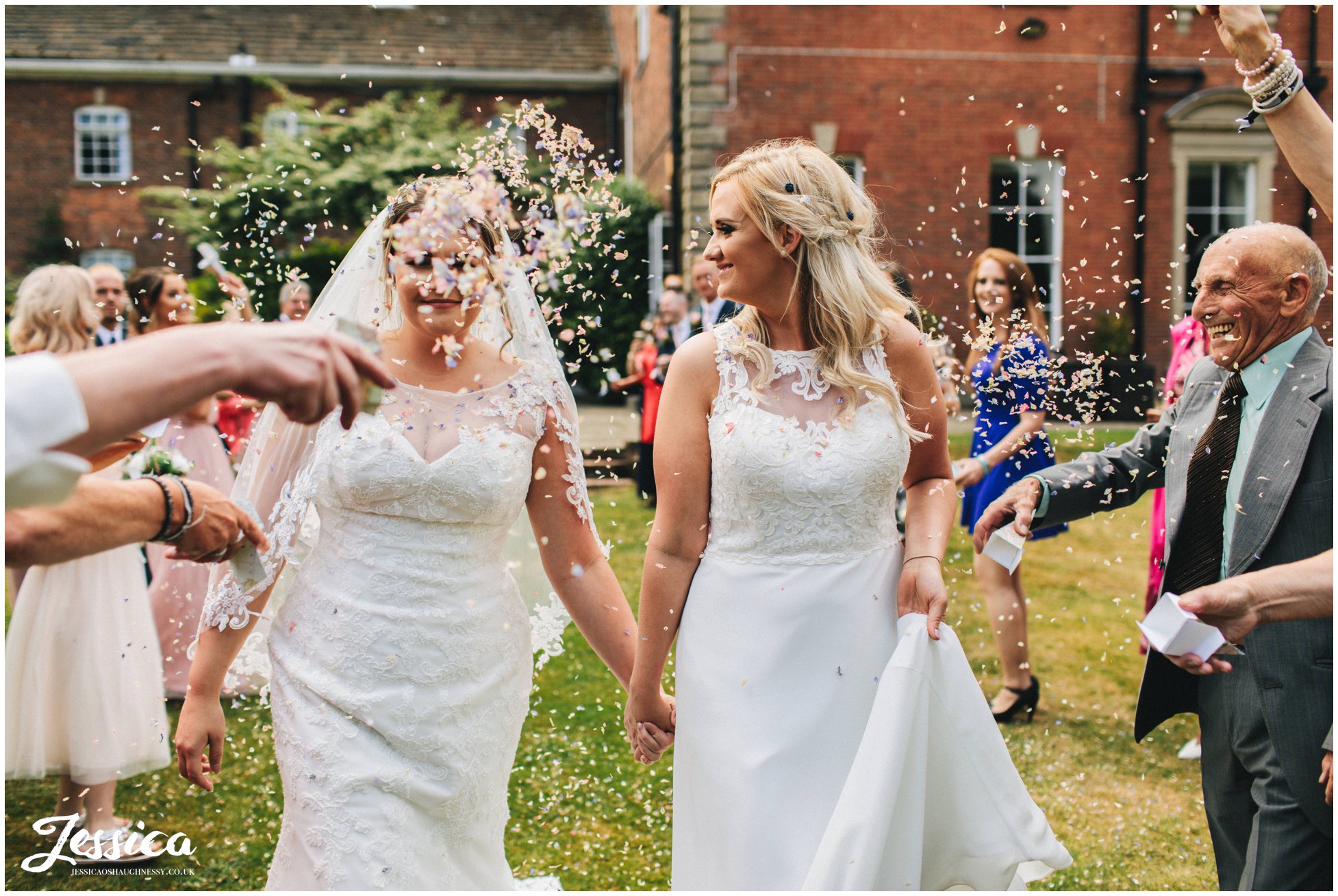 a guest covers one of the brides in confetti