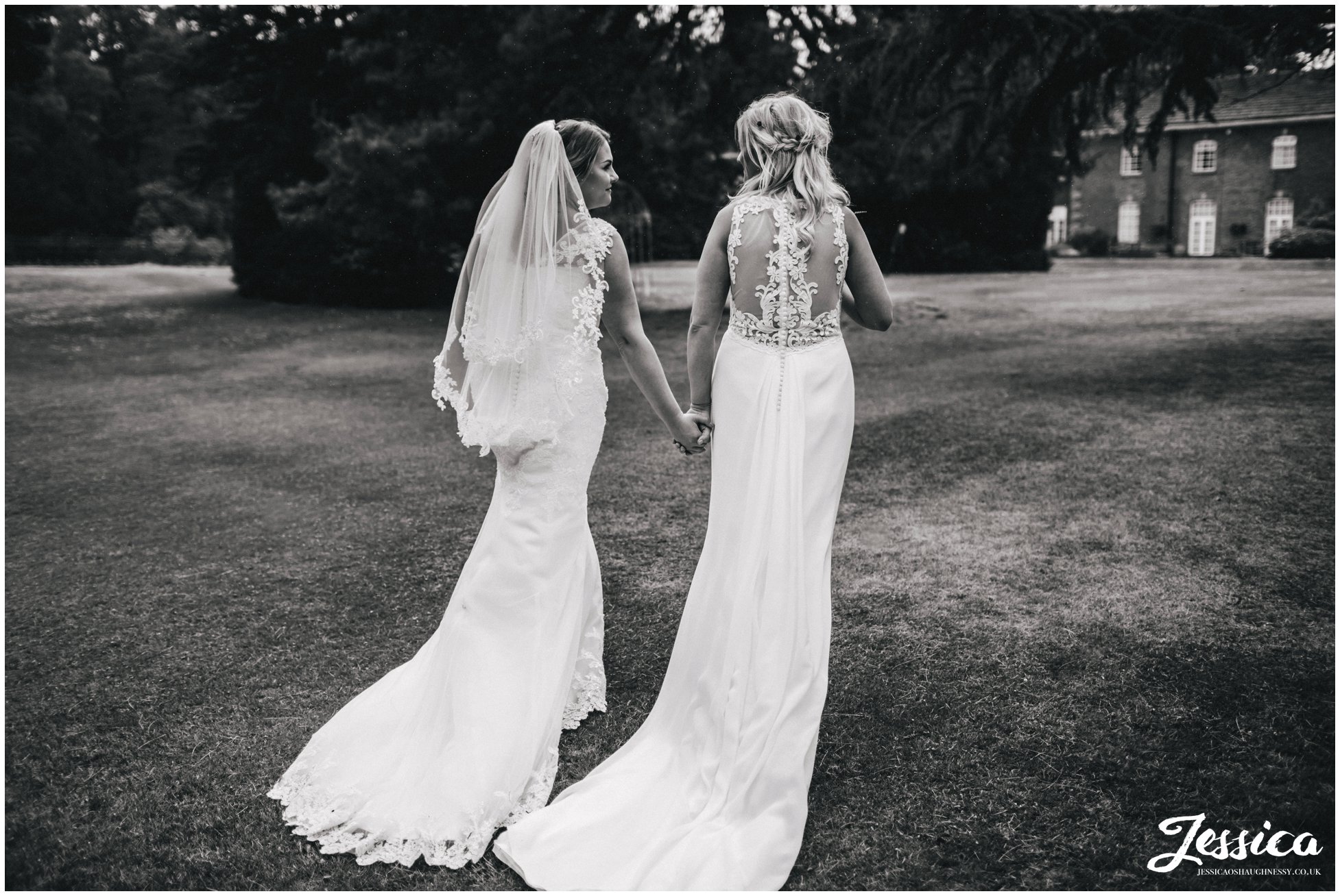 wife & wife walk away from the camera to their wedding reception at mottram hall