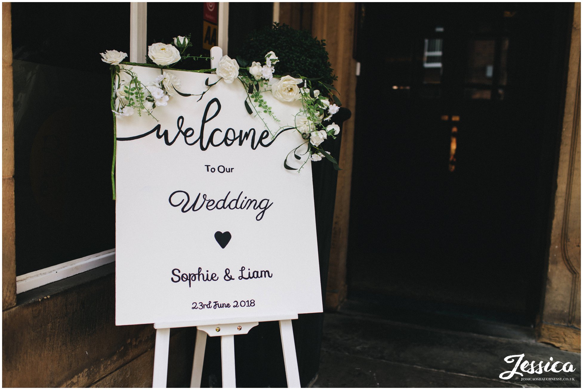 hand painted sign welcomes wedding guests into the venue