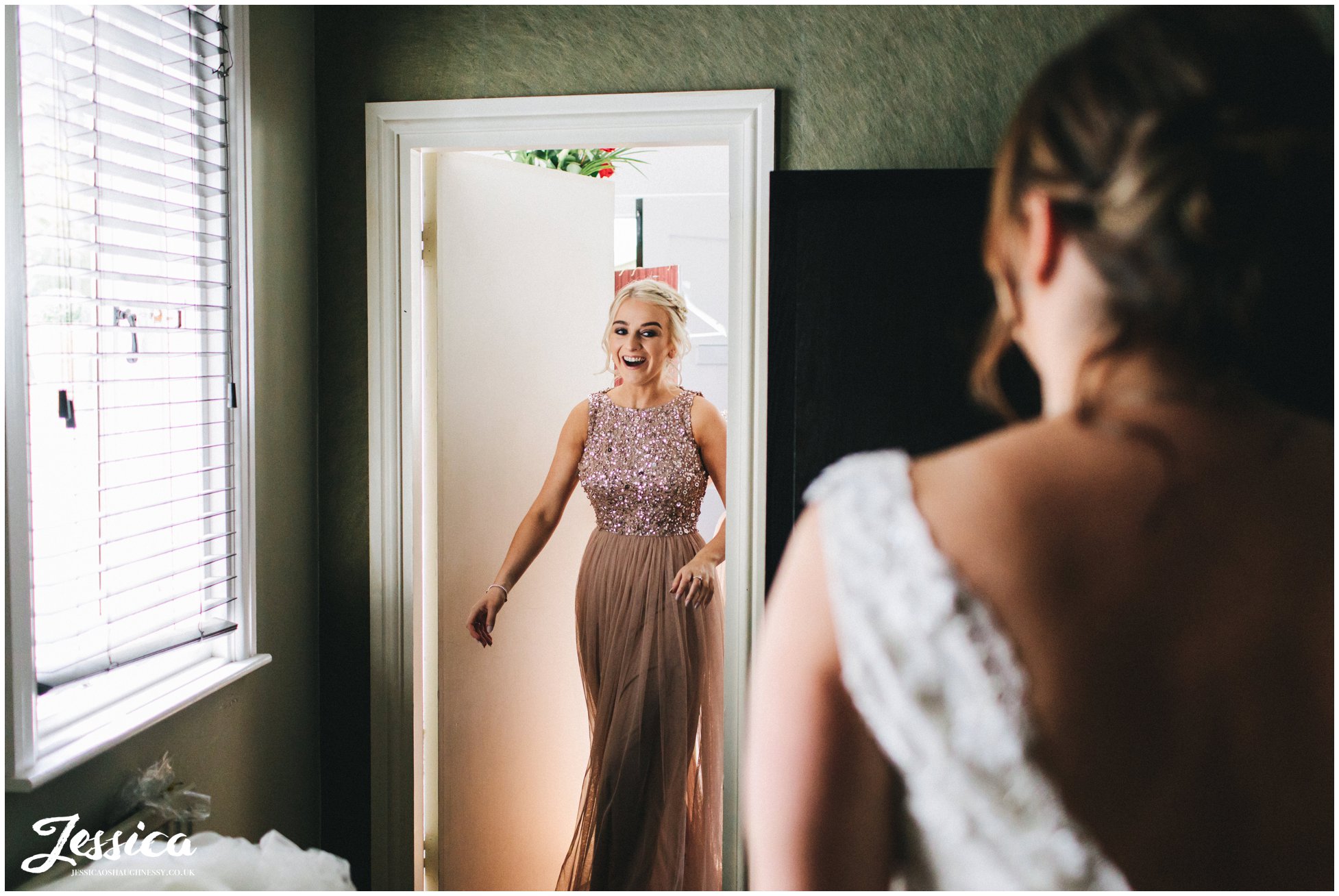 the bridesmaids enter to see the bride in her dress for the first time