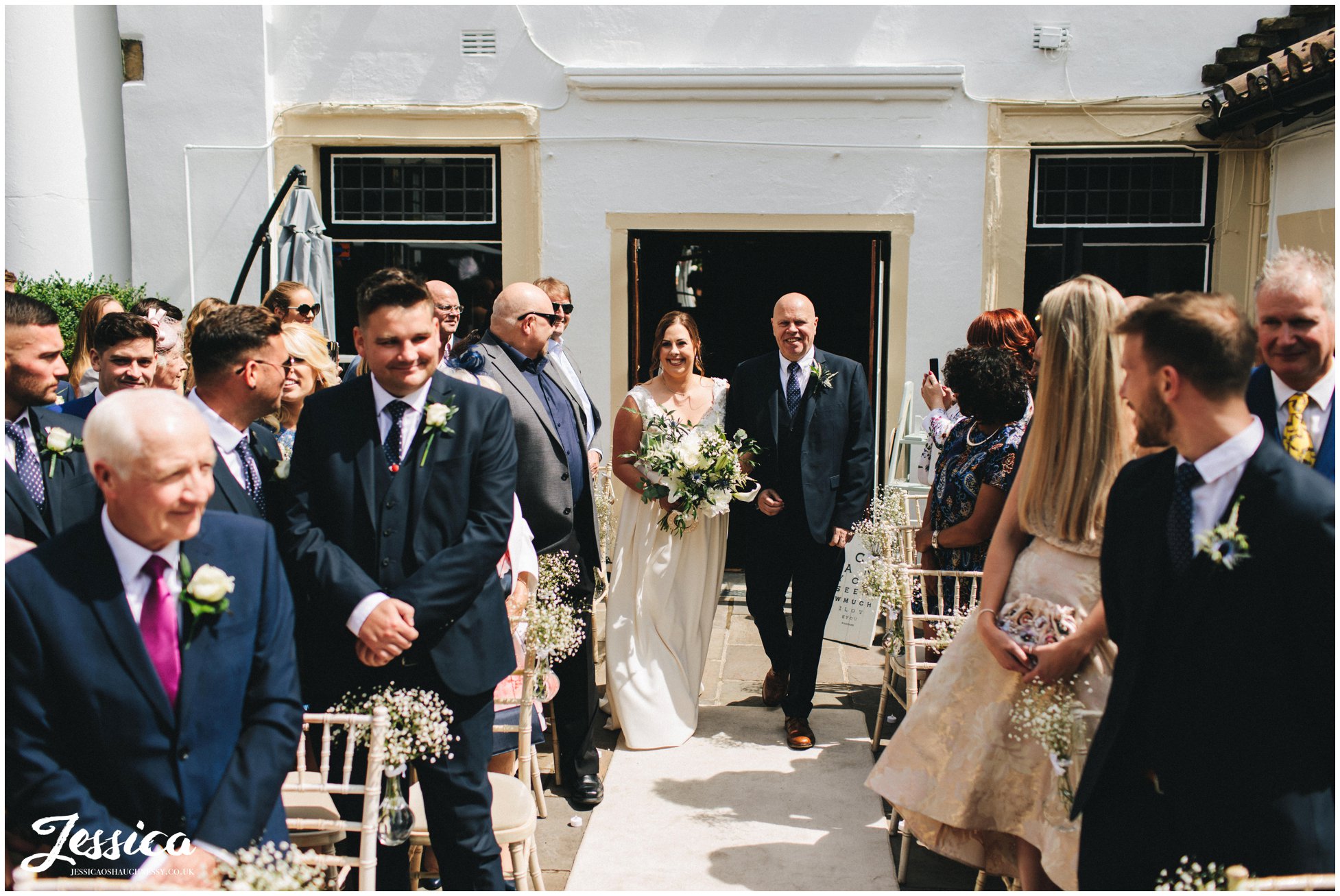 the bride walks down the aisle with her father