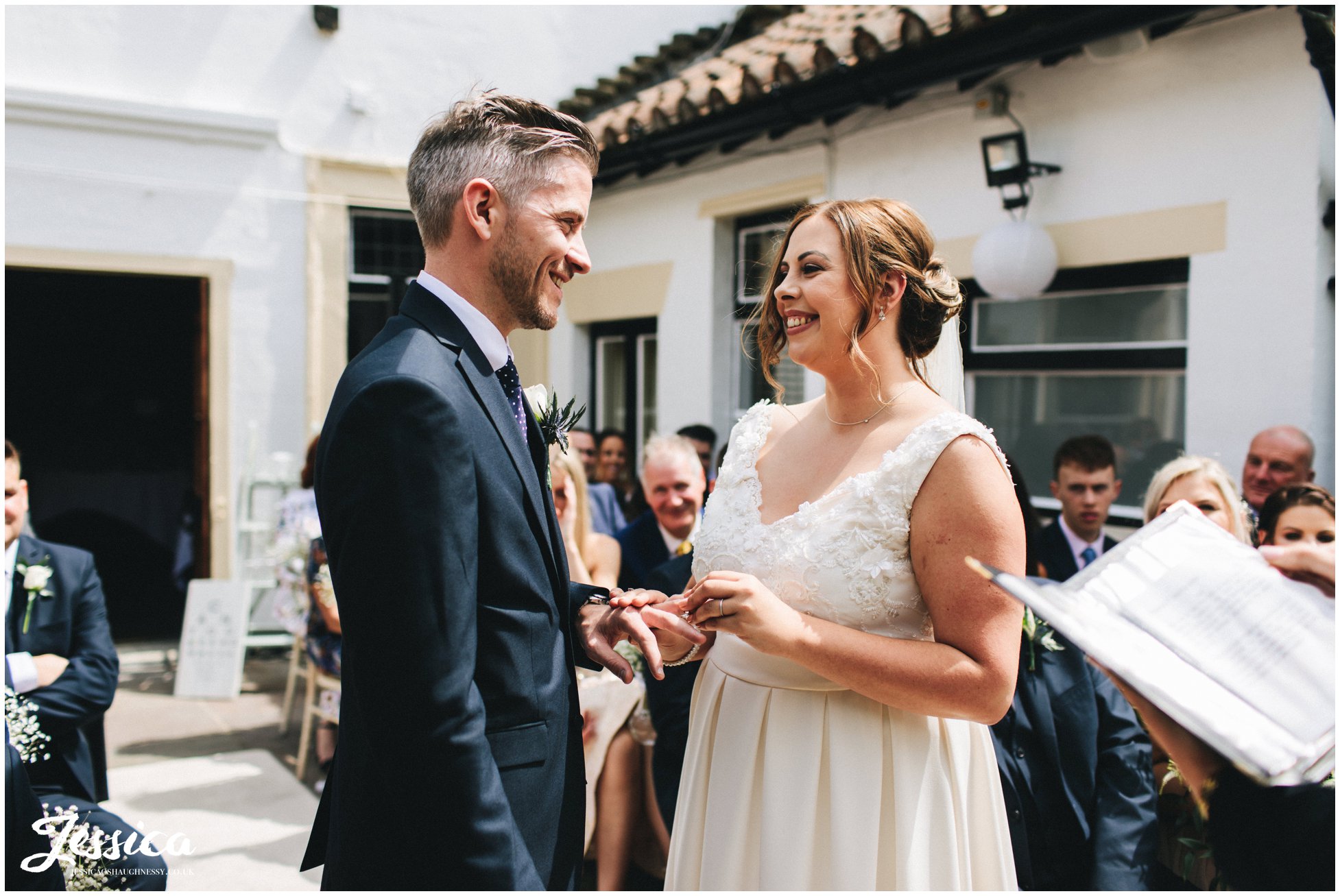 the bride places a ring on the groom finger at their cheshire wedding