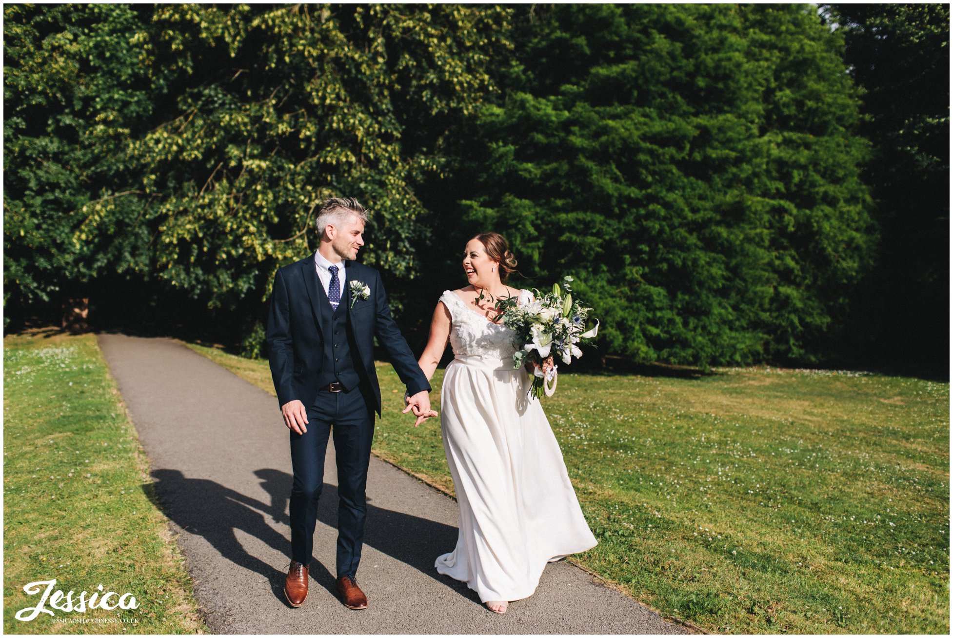 the couple laugh walking along in the sunshine