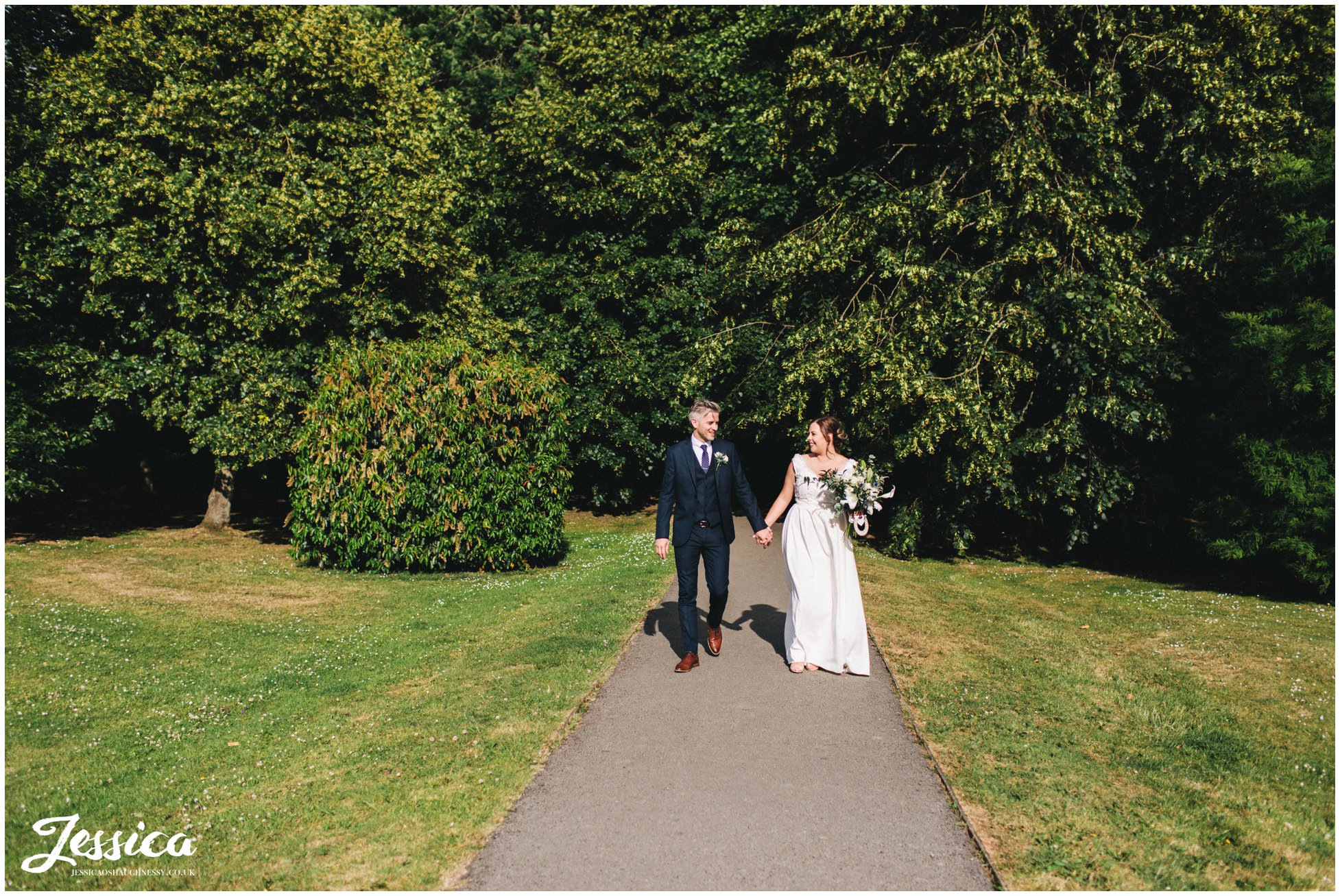 the couple walk hand in hand through the cheshire park in knutsford