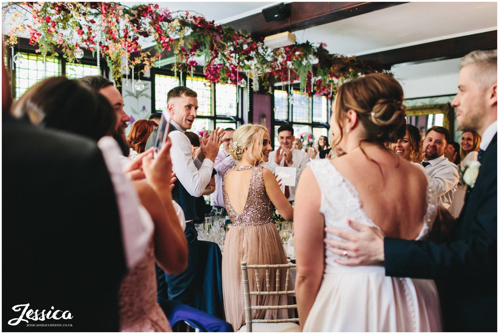 guests applaud as the couple enter the garden room at belle epoque