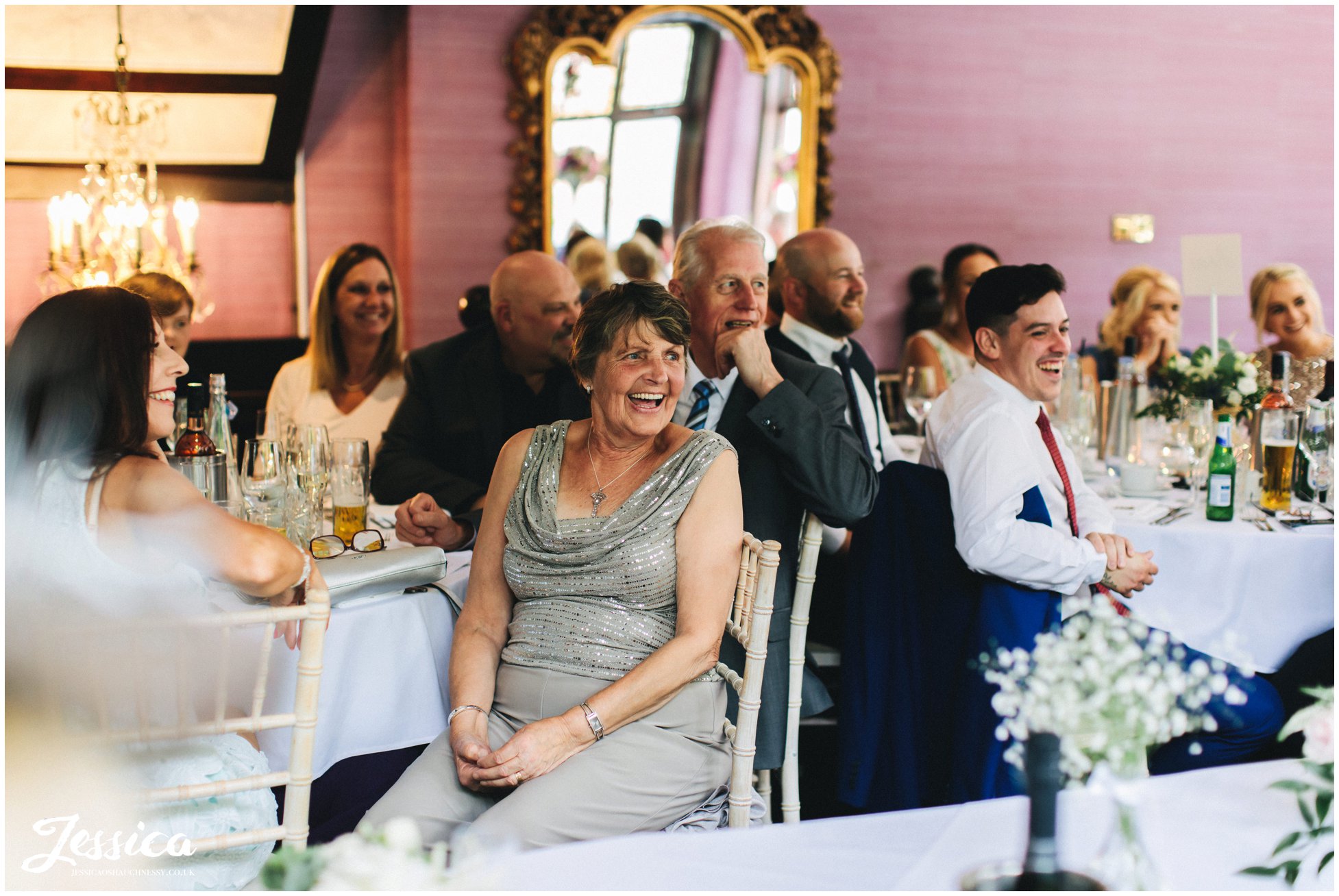 the groom's family laugh along to the speeches in the garden room