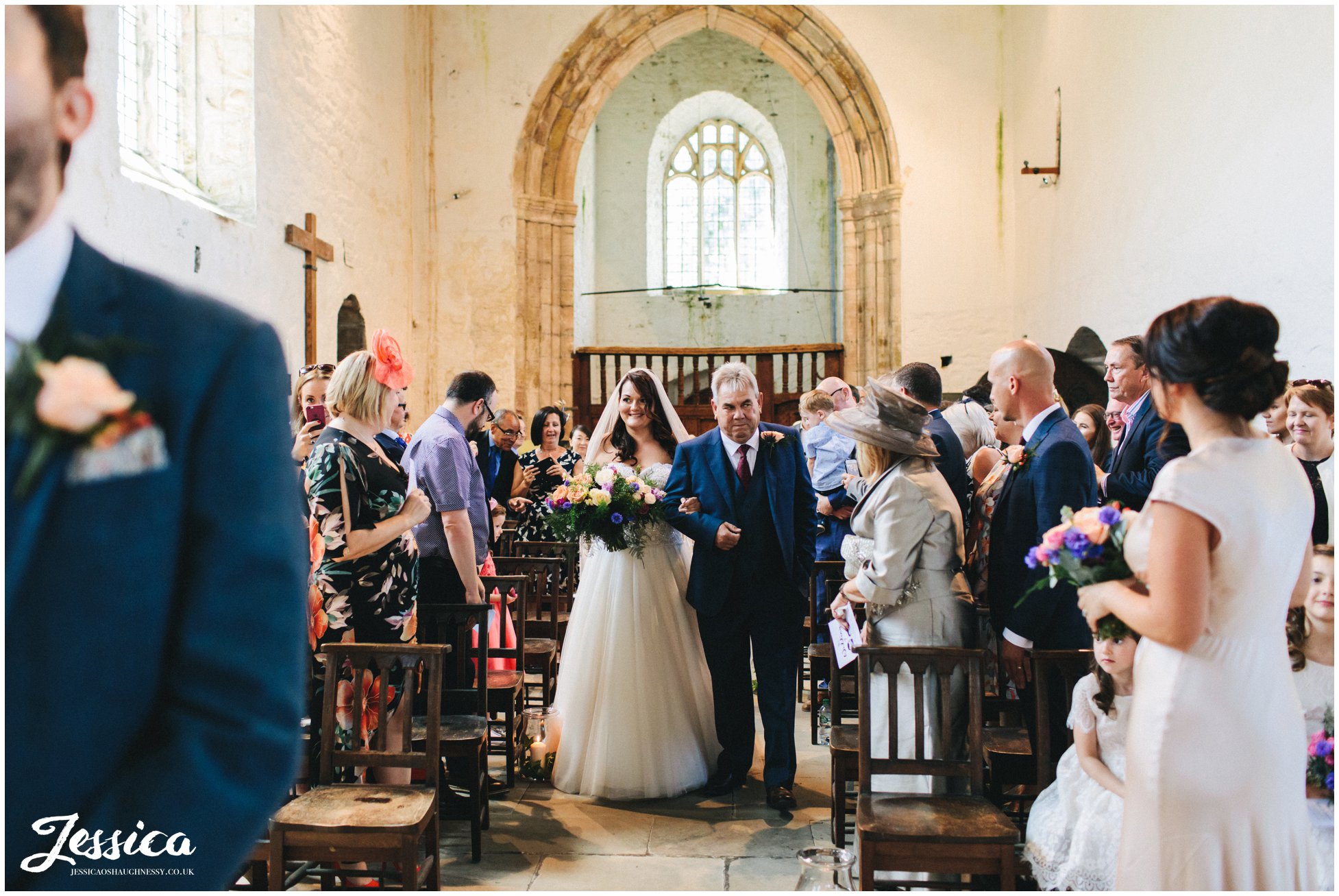 the bride & her father walk down st beuno's aisle