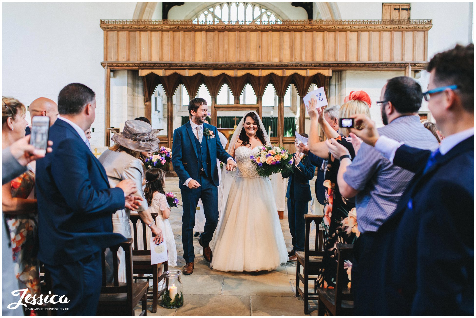the new husband and wife walk back down st beuno's aisle married