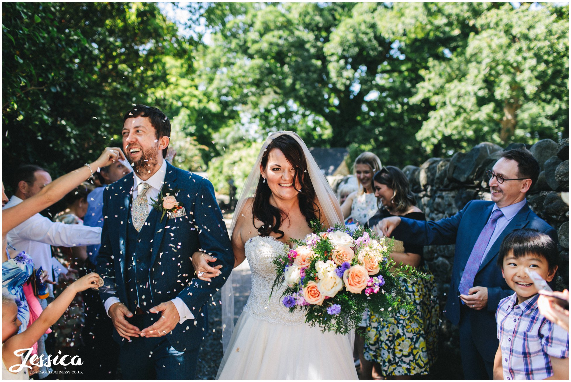 the newly wed's get showered with confetti after their wedding ceremony