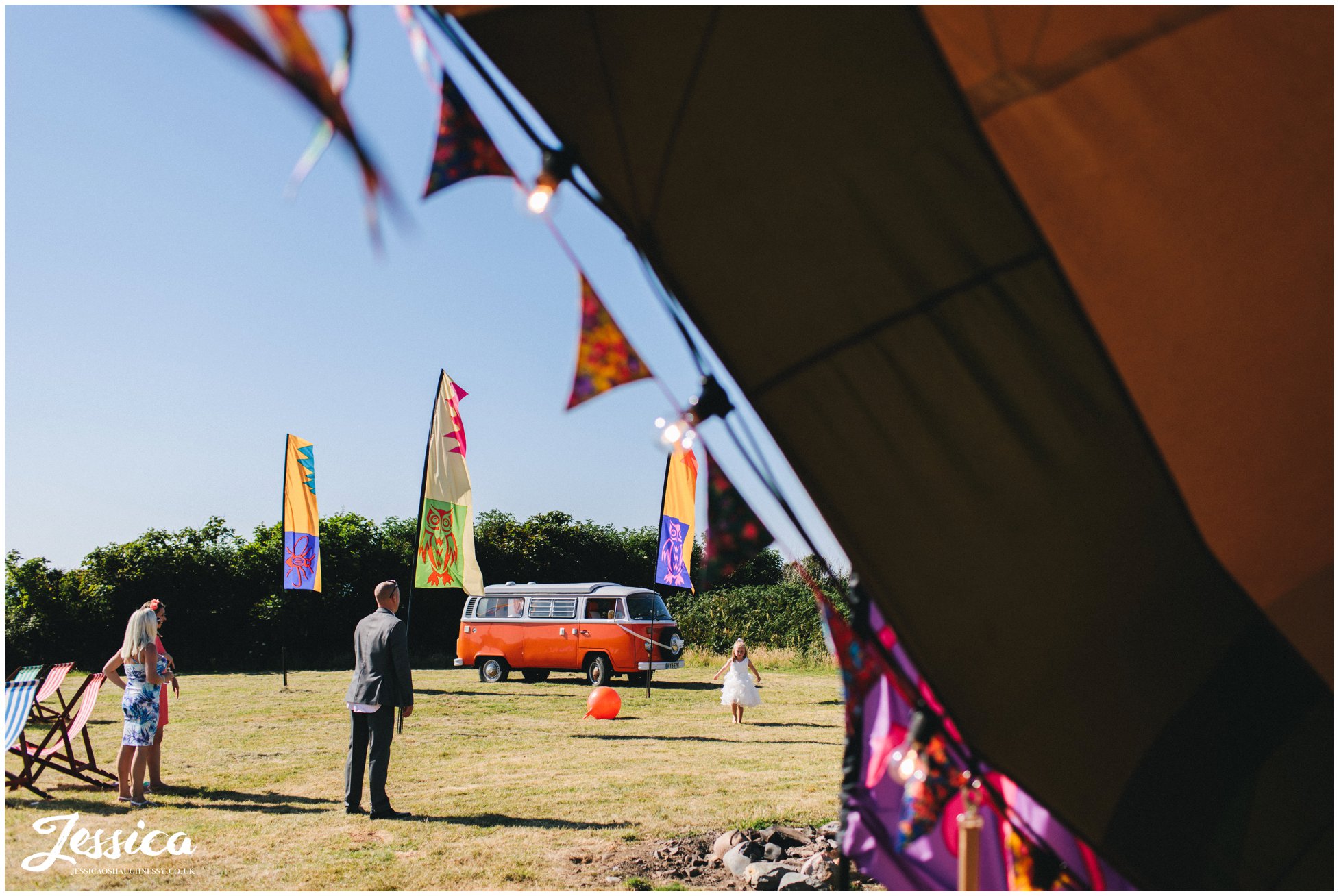 vw camper is parked on the field with the tipi