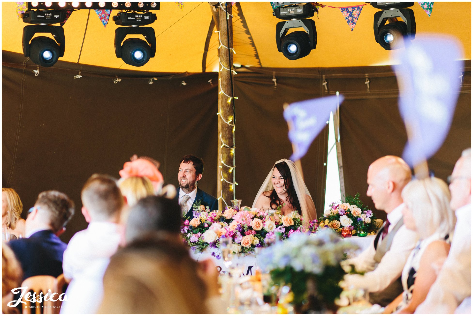 the bride & groom smile as the best man gives his speech at bach wen farm