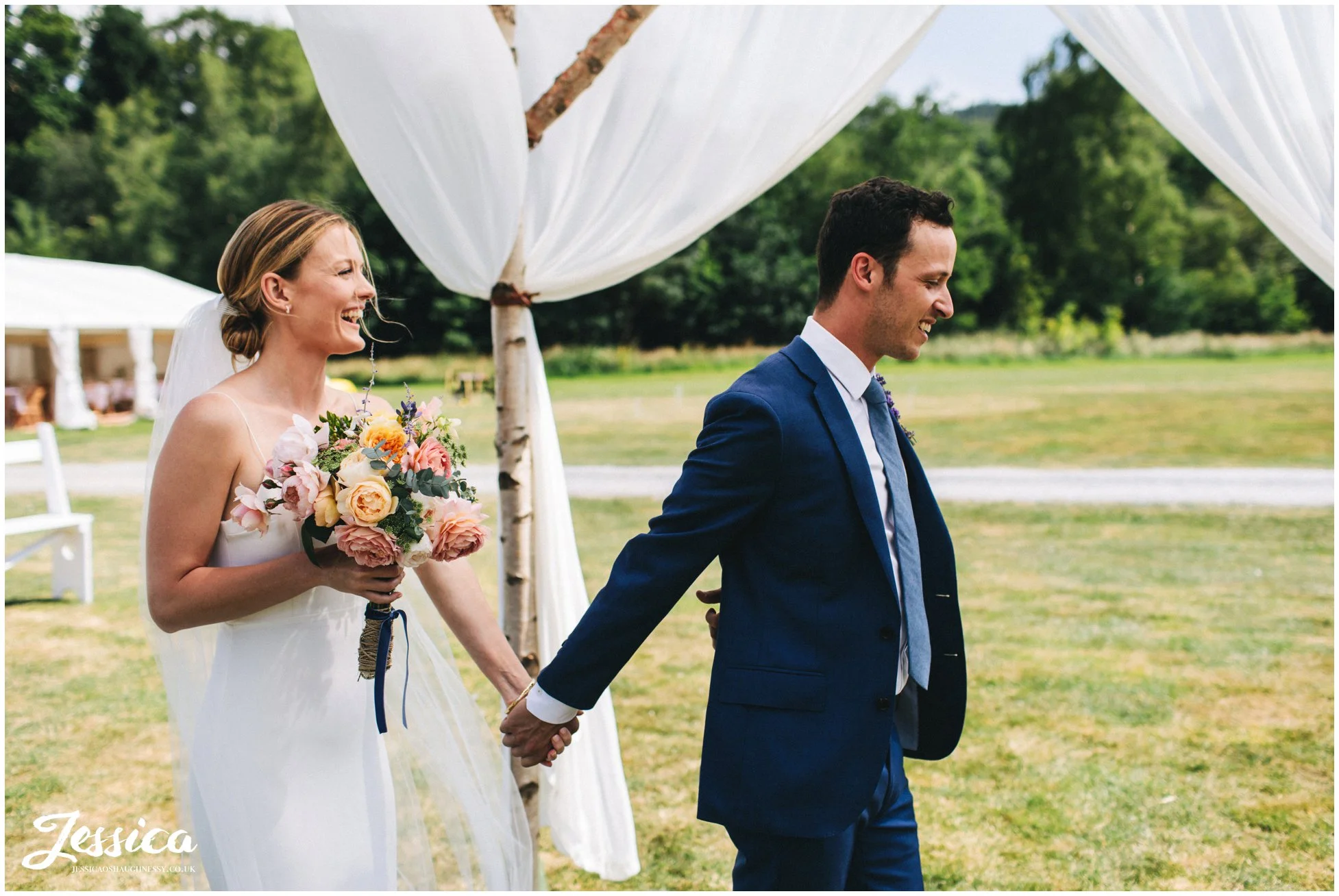 the bride takes her grooms hand before he turns to see her