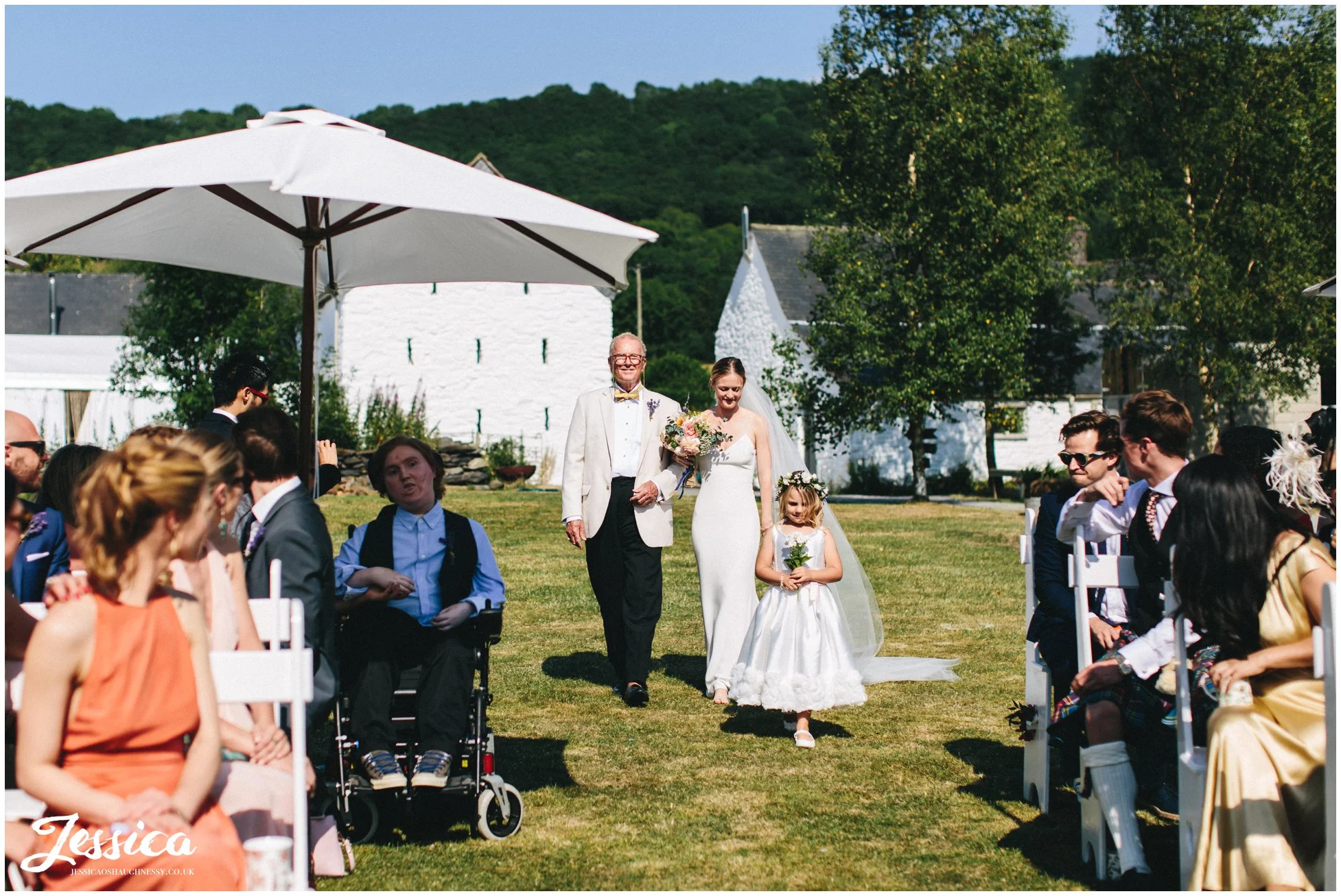the bride walks with her father down the aisle