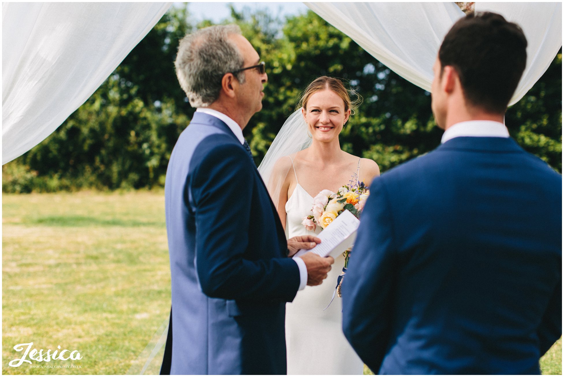 the bride smiles at the celebrant during the service