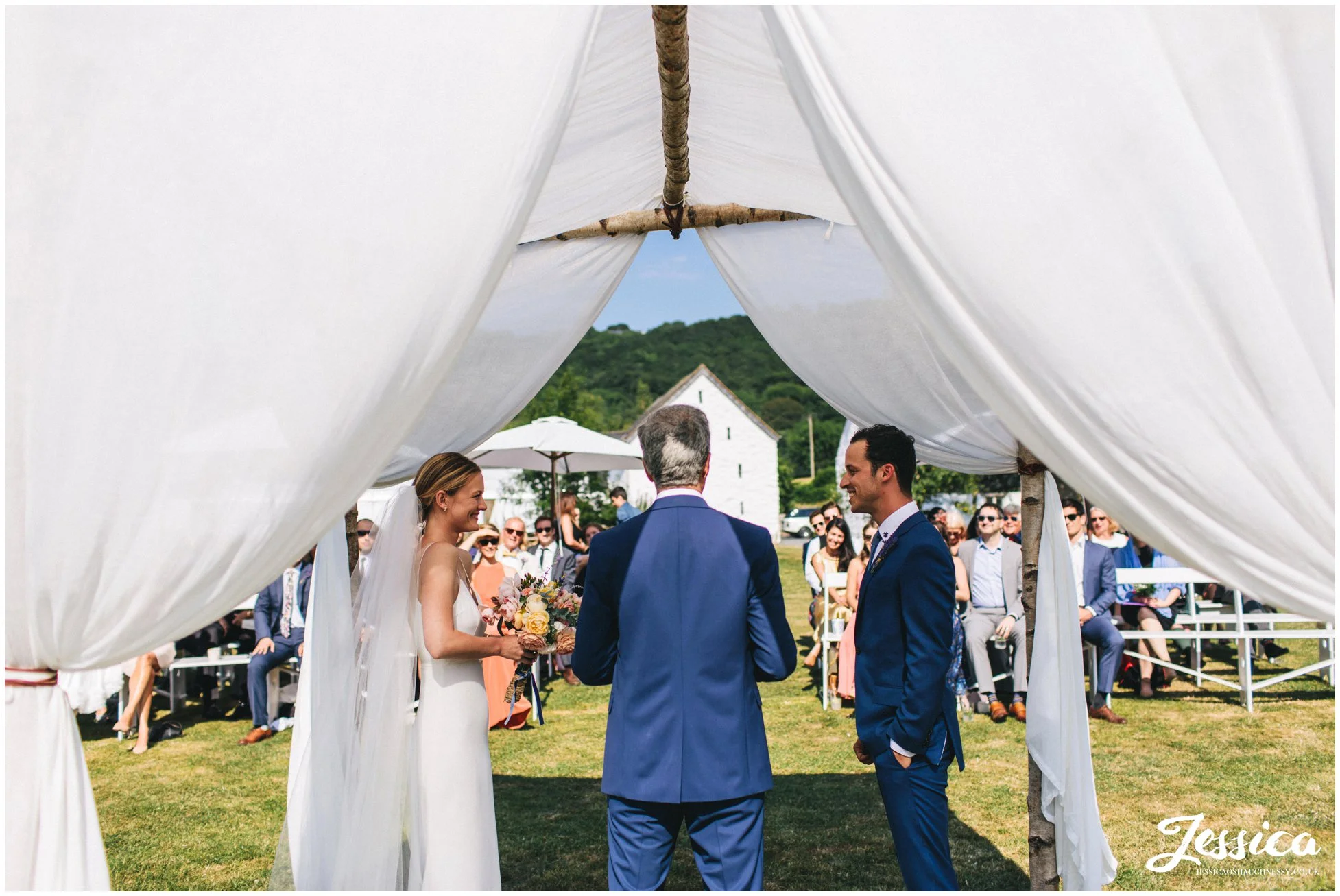 the couple have their wedding ceremony under the chuppah