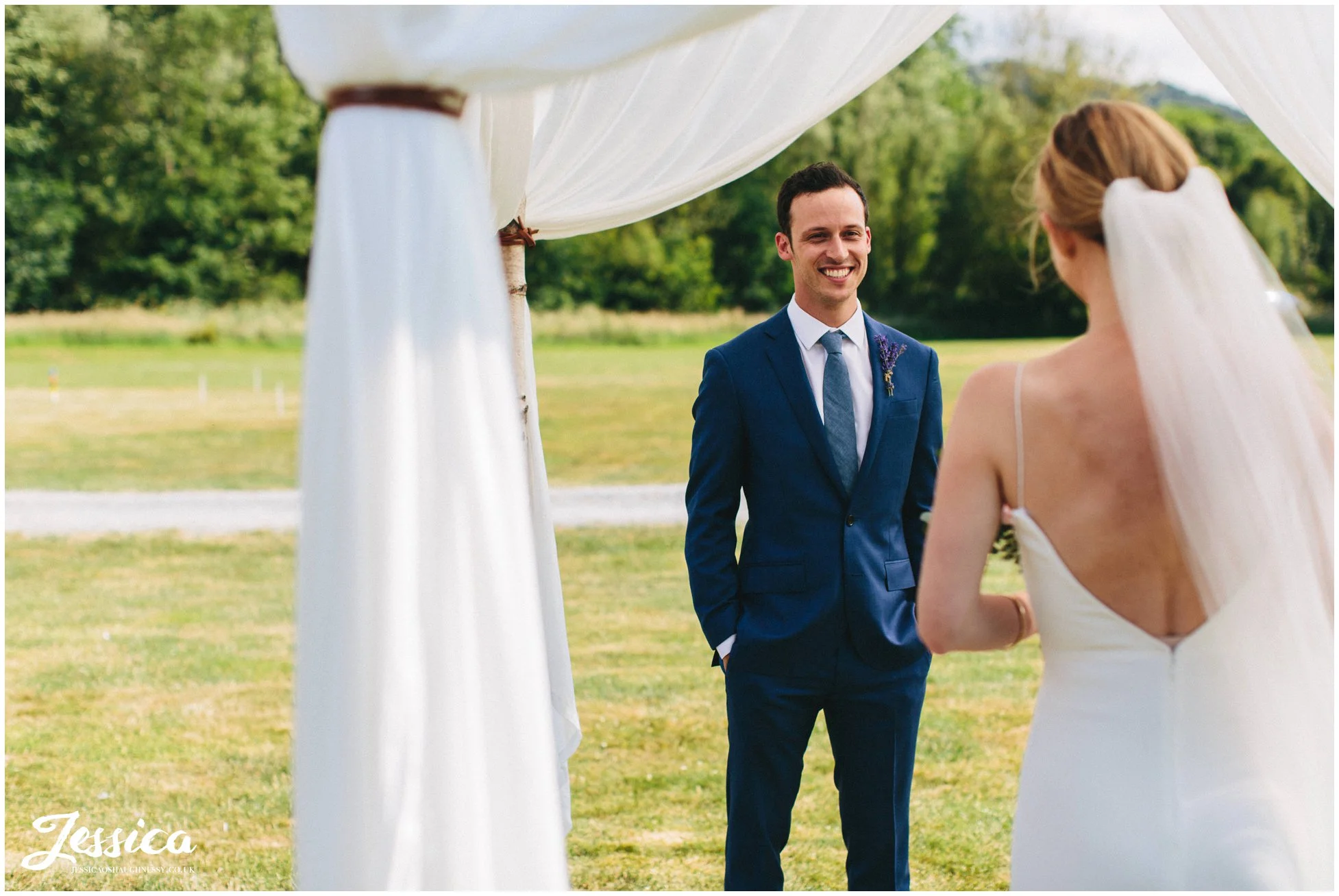 the groom admires his bride at hafod farm during the wedding ceremony