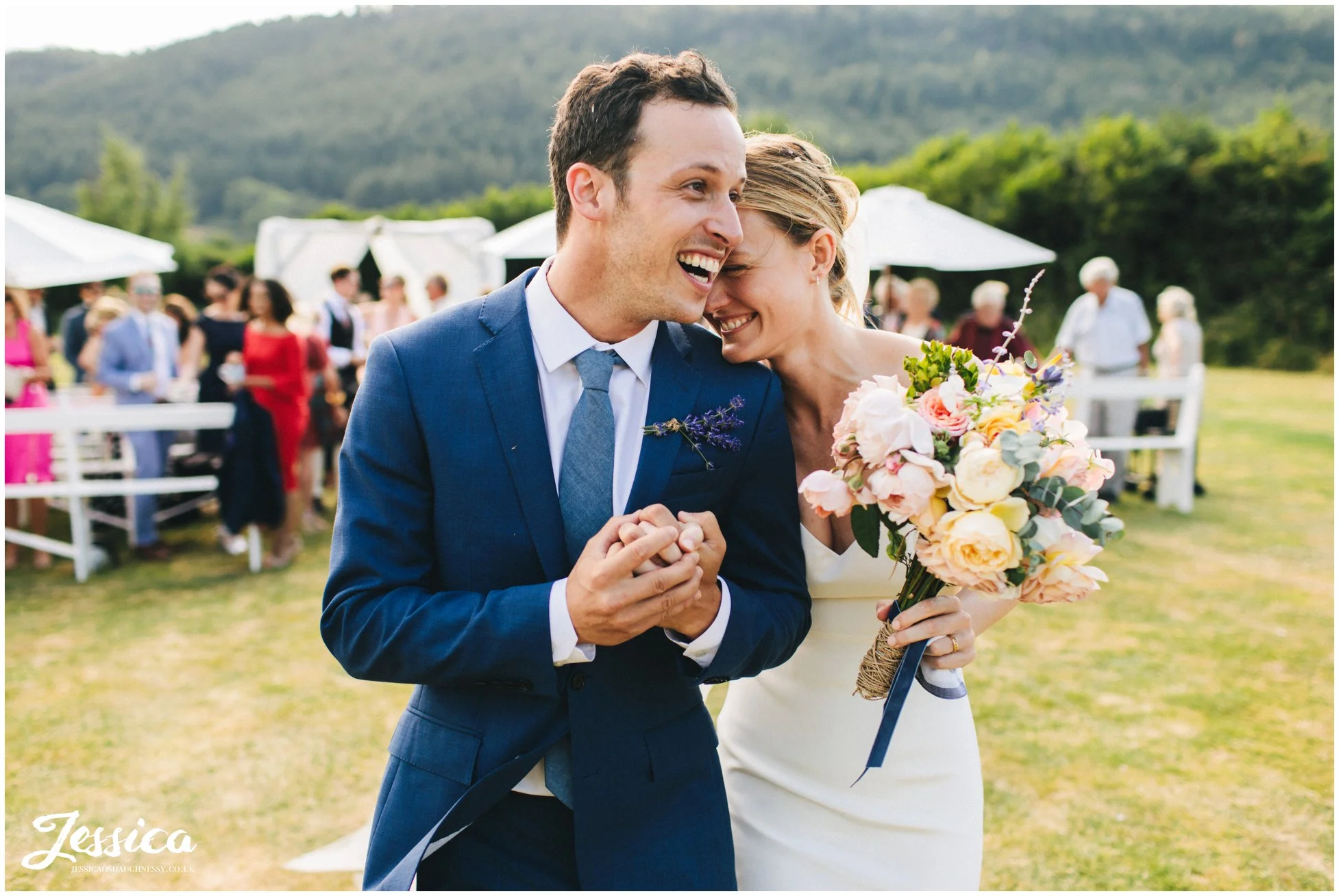 groom embraces his bride as they walk out of their wedding ceremony